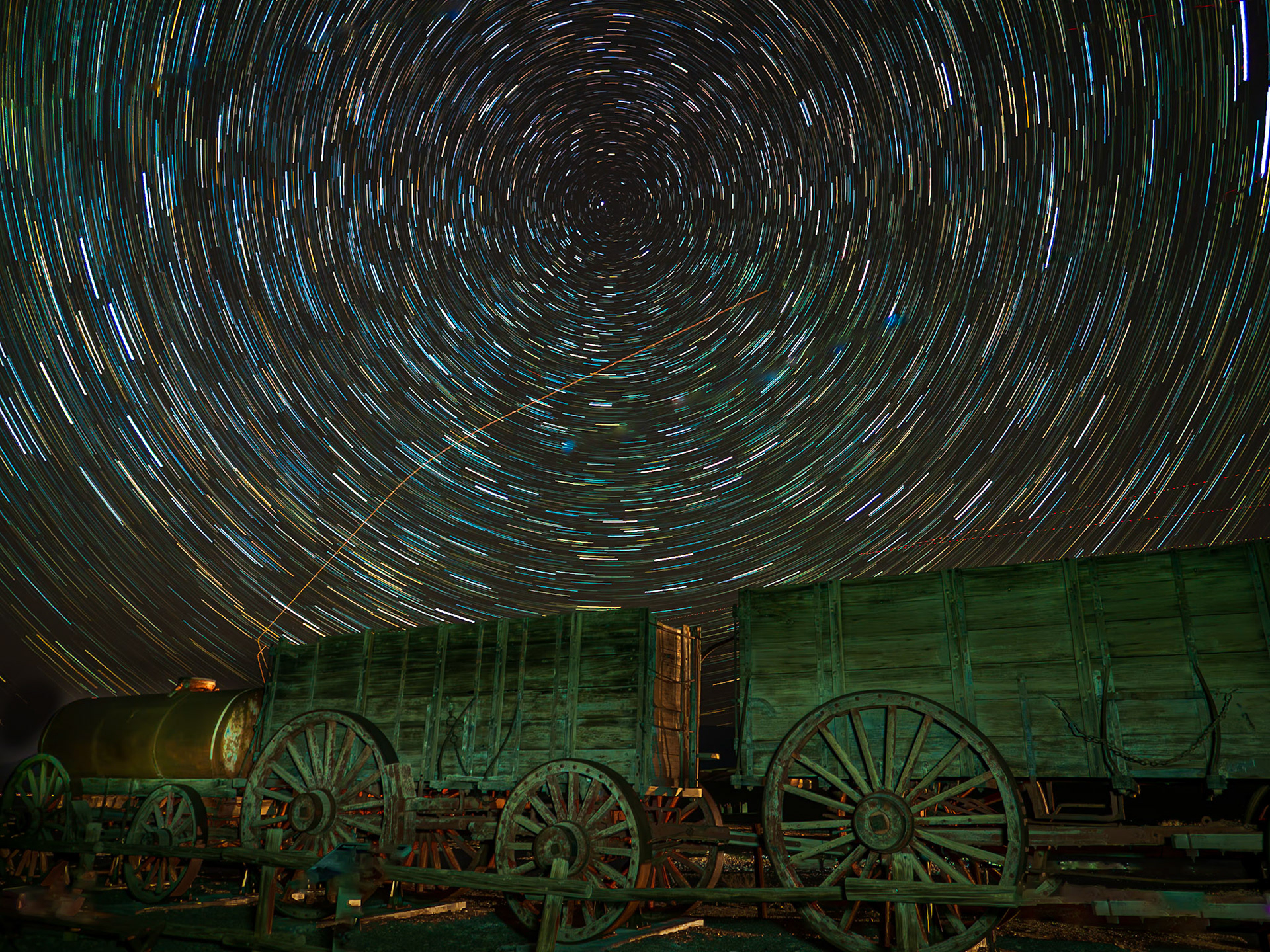 Wagons Under the Stars: 20-mule team wagons sit under a kaleidoscope of starsin Death Valley.  These massive wagons with 7-ft high wheels were used to haul up to 10 tens of borax each over 160 miles to a railhaed in Mojave California.