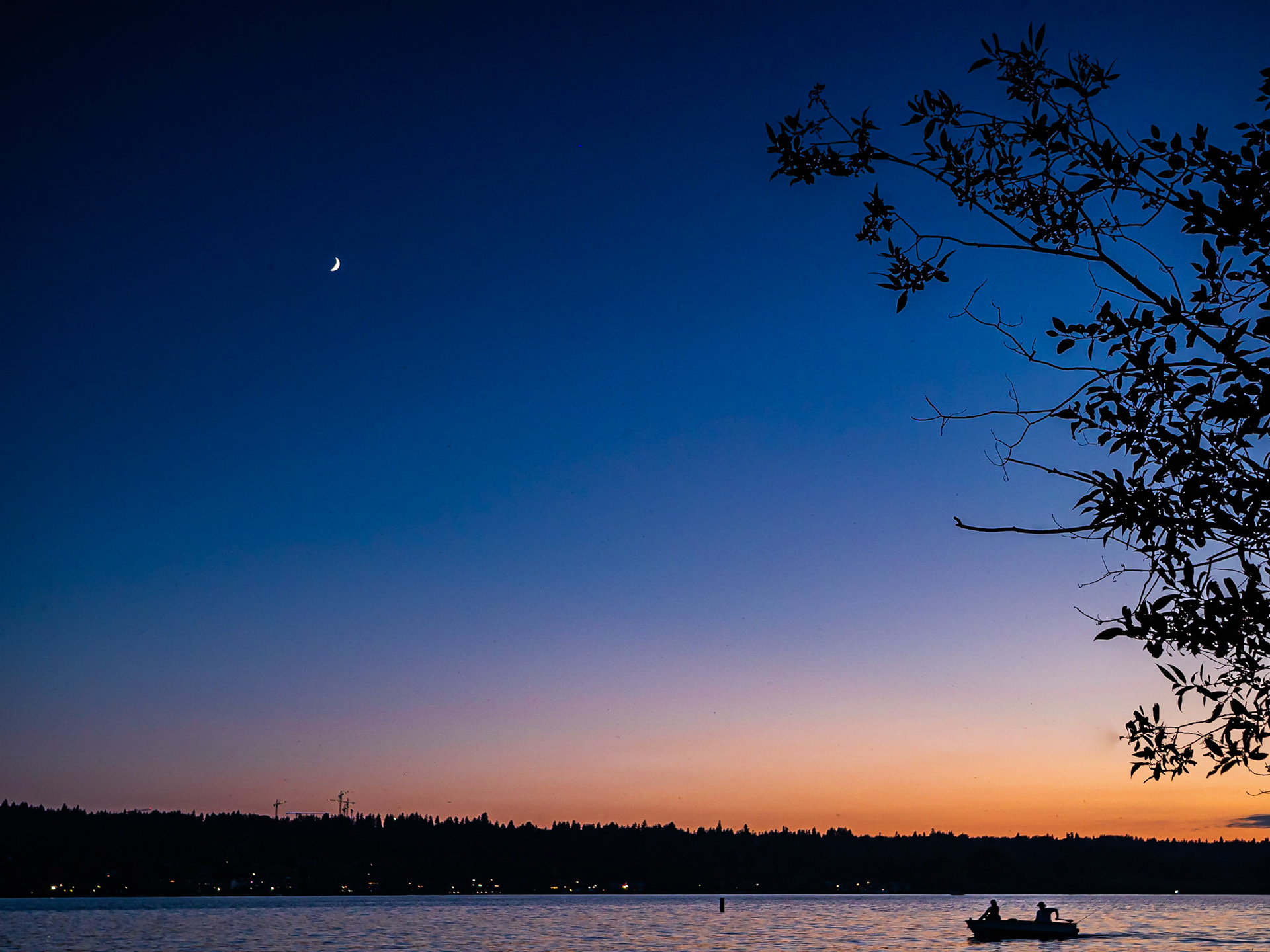 Angling Home: Anglers returing to the dock under a crescent moon setting over Lake Sammamsih in the blue hour after sunset.