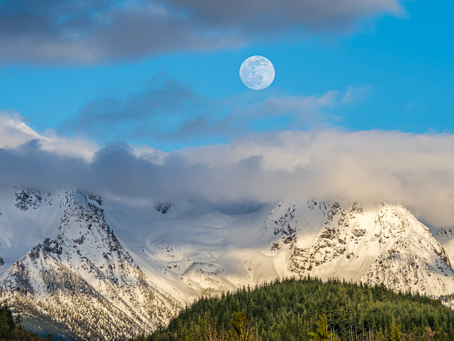 Twin Peaks Moonrise: The clouds parted on an overcast day to reveal the moon rising above Twin Peaks near Mt. Baker in the Washington Cascades