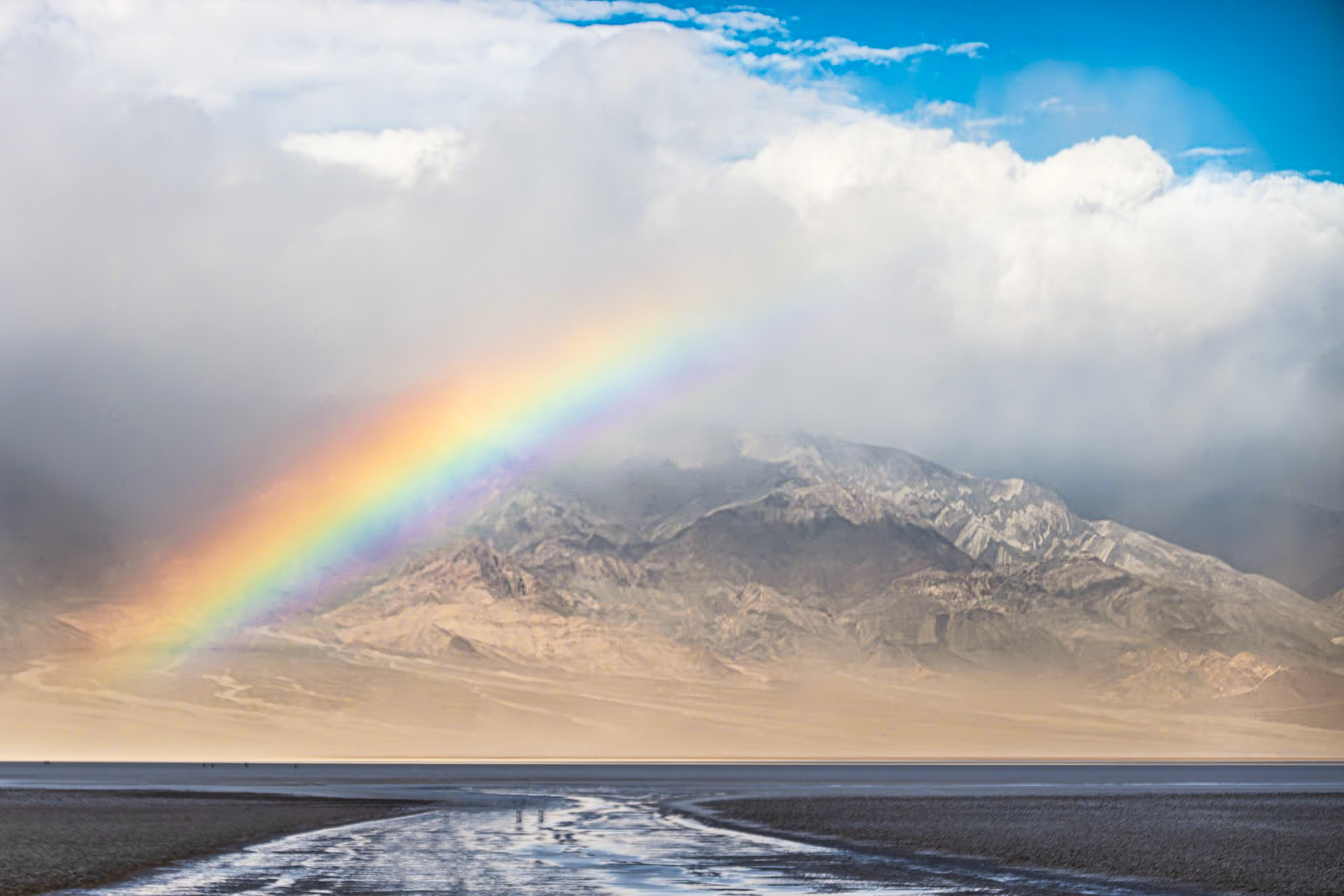 Badwater Rainbow: An ephemeral lake appears at Badwater Basin following unusual winter rains in Death Valley.
