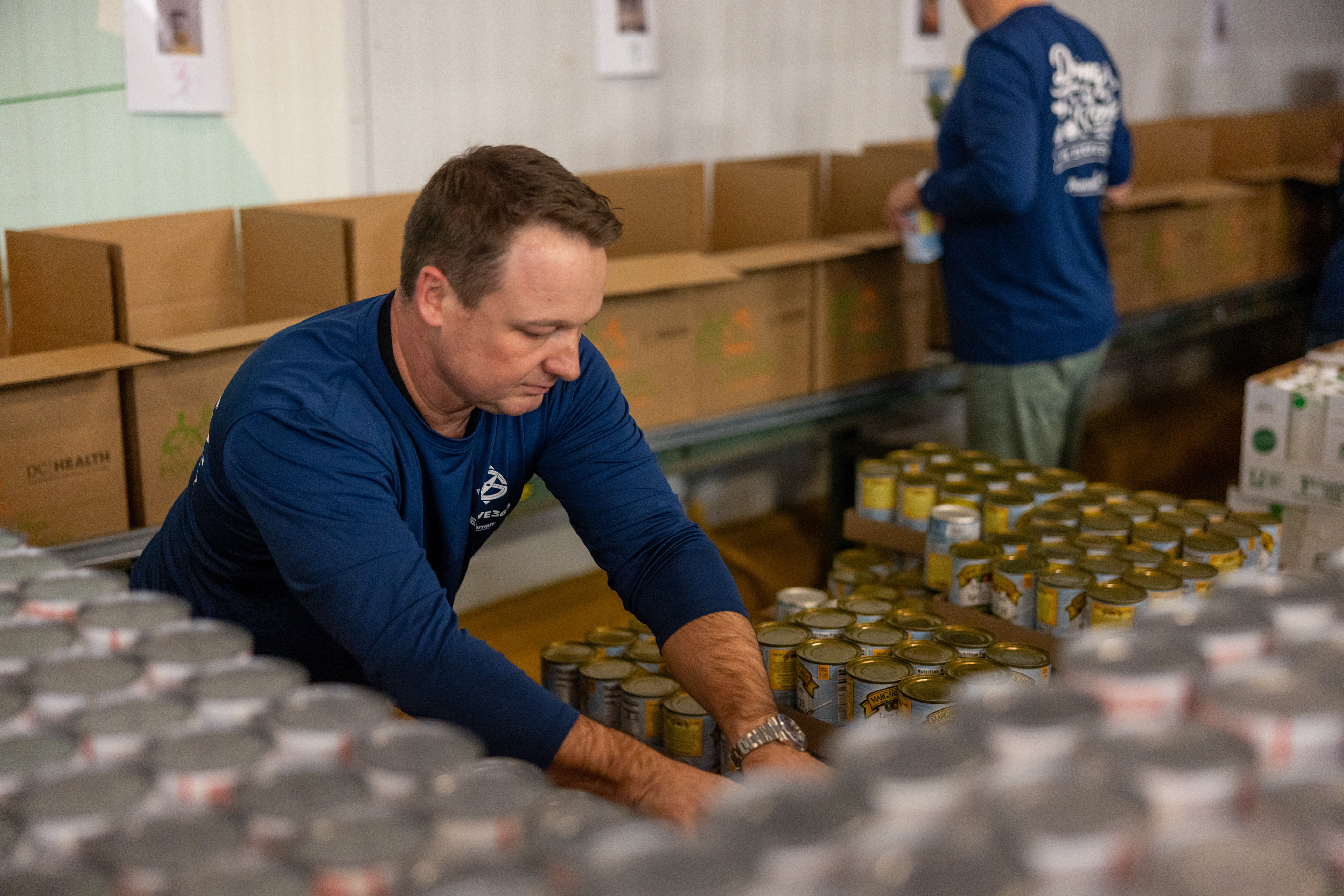 Ty Breland, EVP and Chief Human Resources Officer, packs food for distribution
