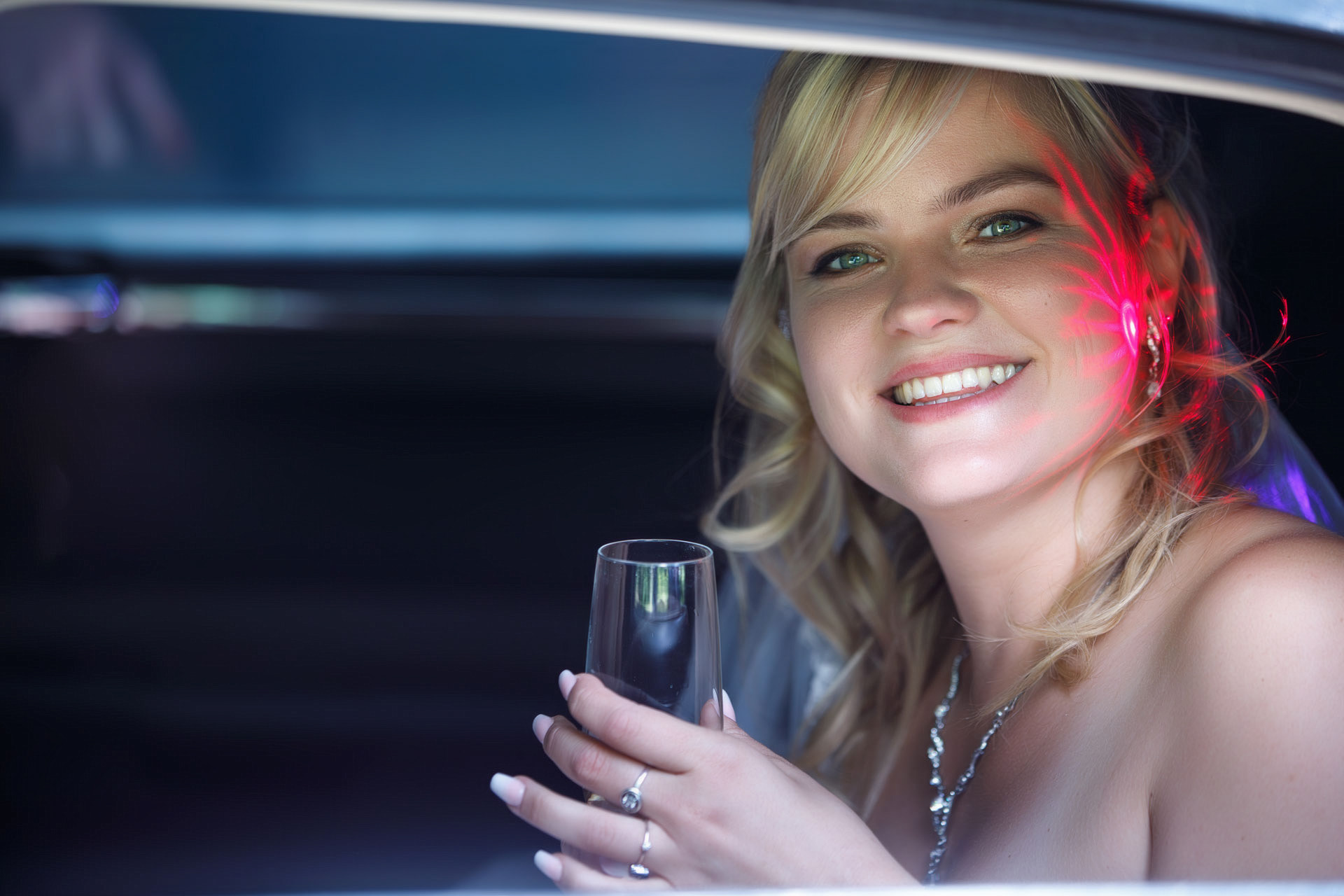 Braut fotografiert am Fernster einer Stretchlimousine