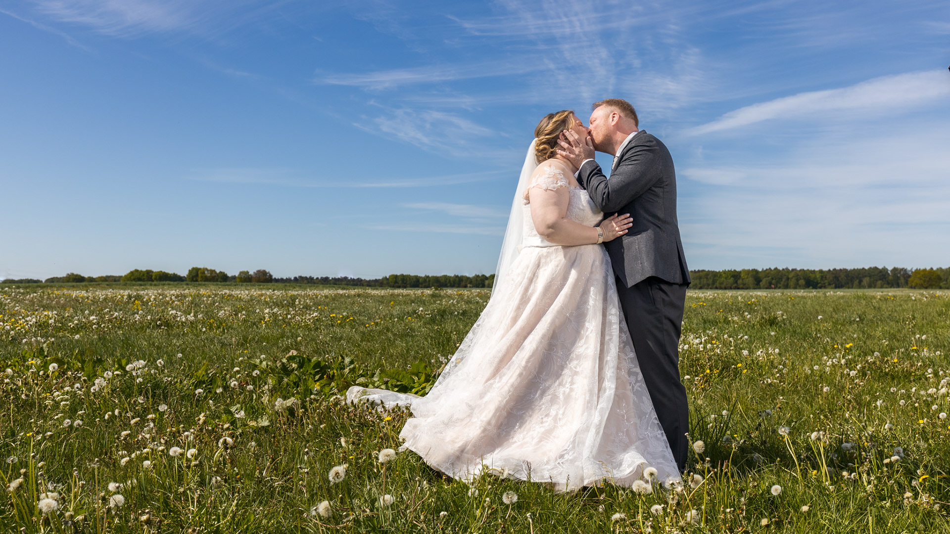 Hochzeitspaar küssend auf einer Wiese