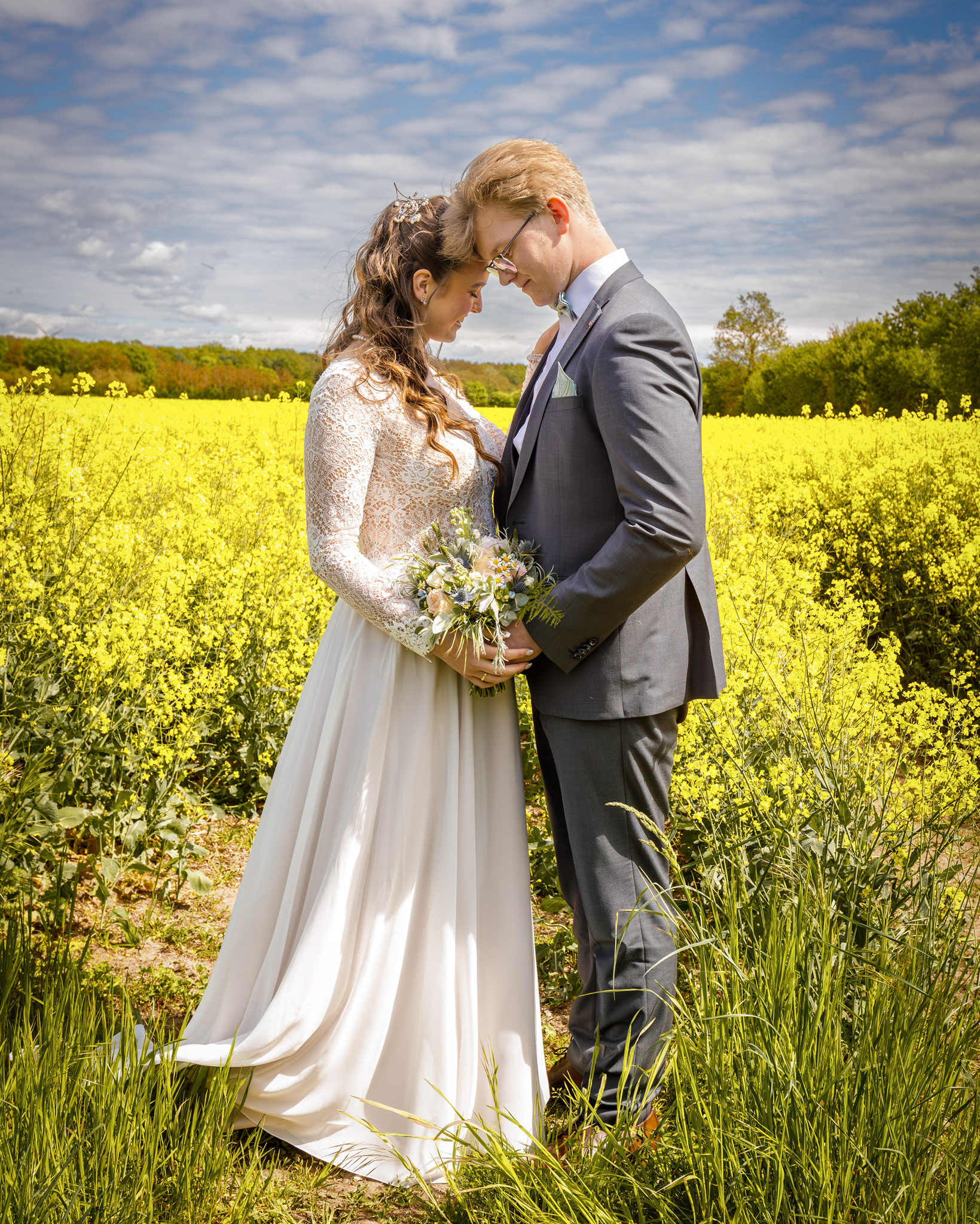 Hochzeitspaar in einem blühenden Rapsfeld
