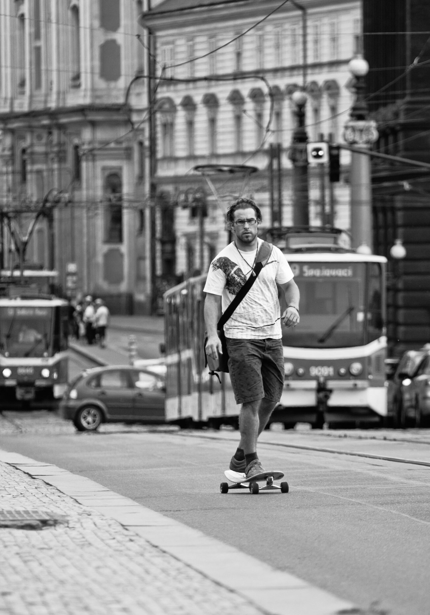 Мужчина на лонгборде едет по мосту в Праге