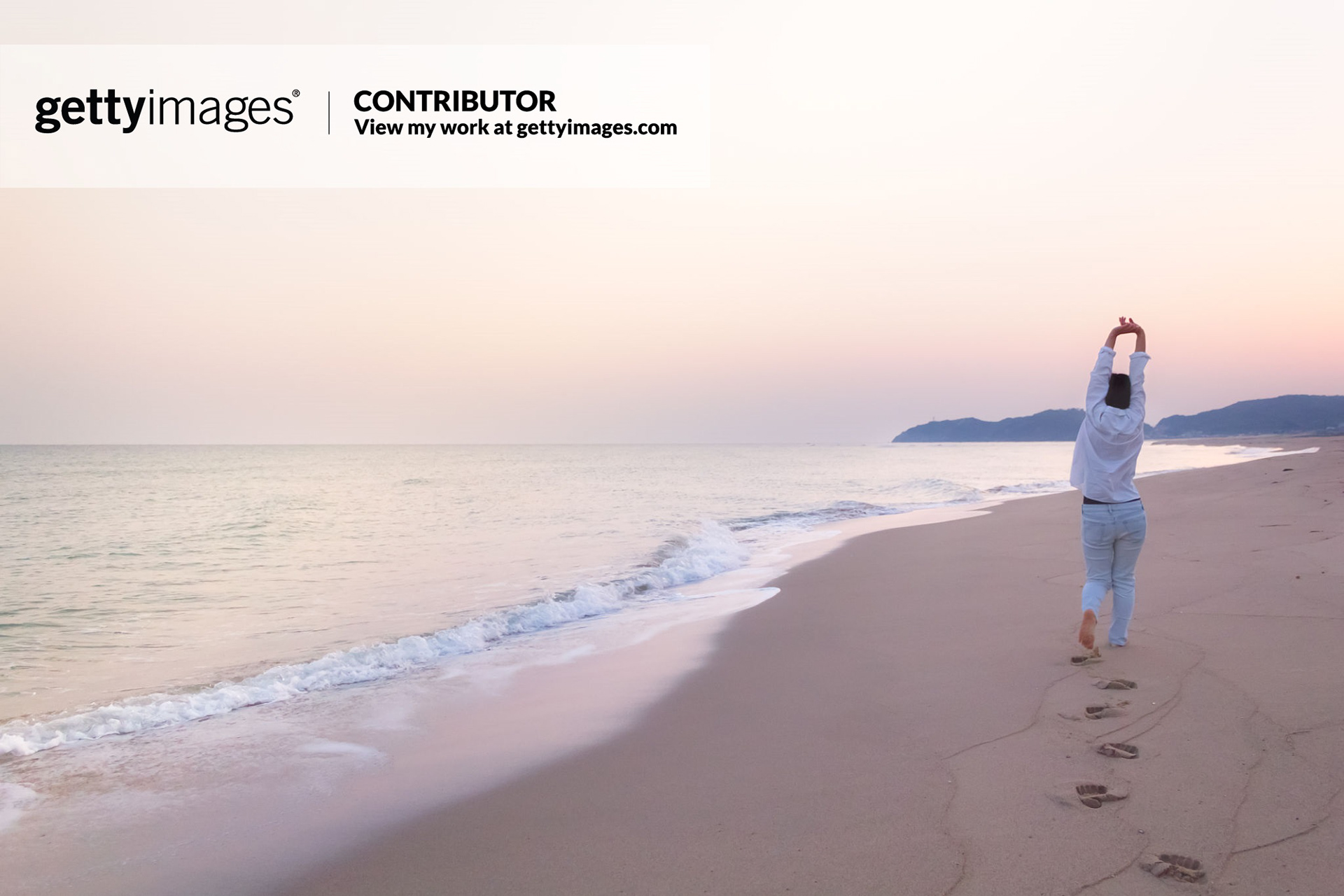 Woman and a Calm Beach in Dawn - stock photo Landscape image of a Japanese woman stretches out her hands while walking on a beach in dawn. This image was taken in April 2015, Shimane Prefecture, Japan.