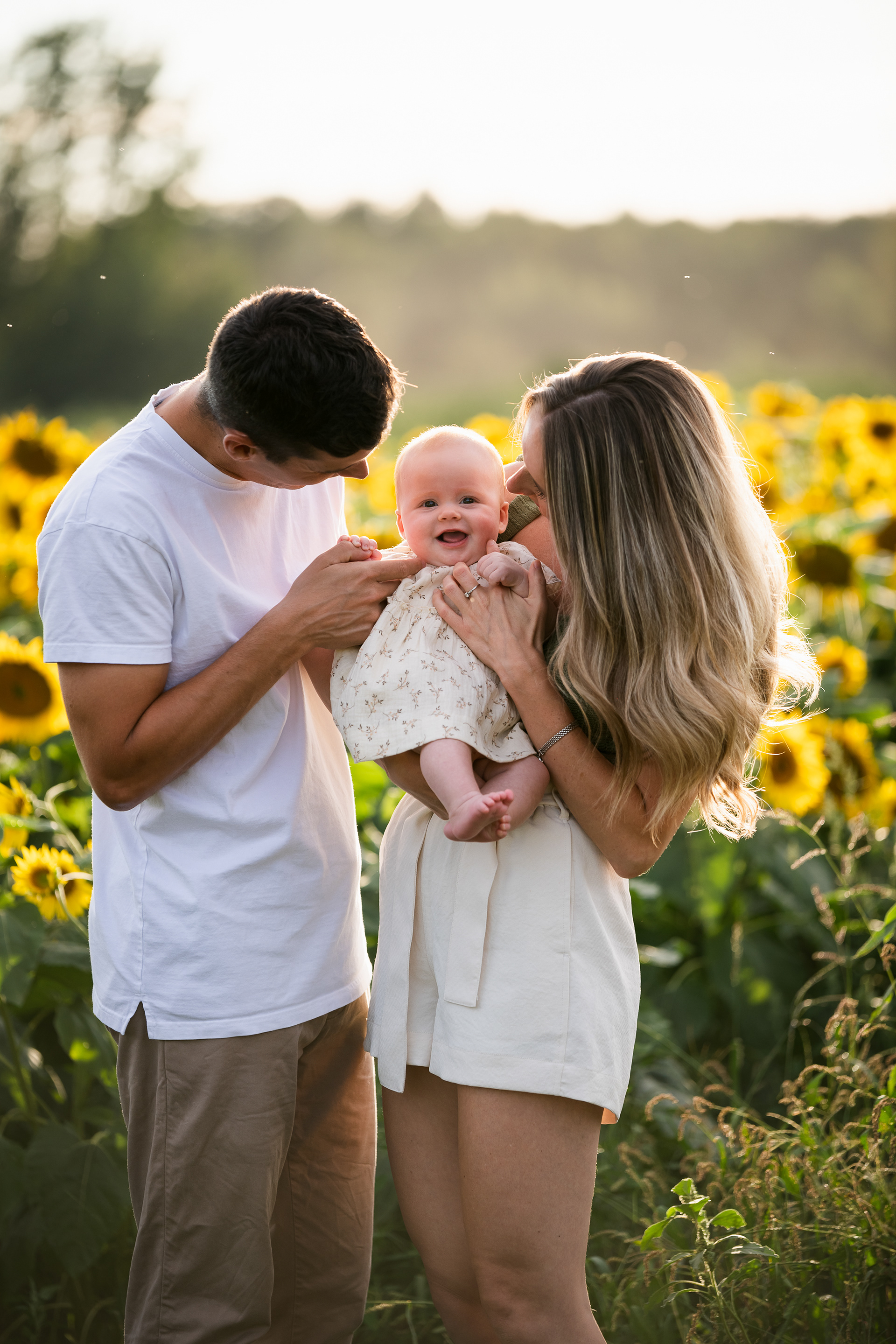 Séance photo de famille avec bébé dans les champs de tournesols à Rougemont.