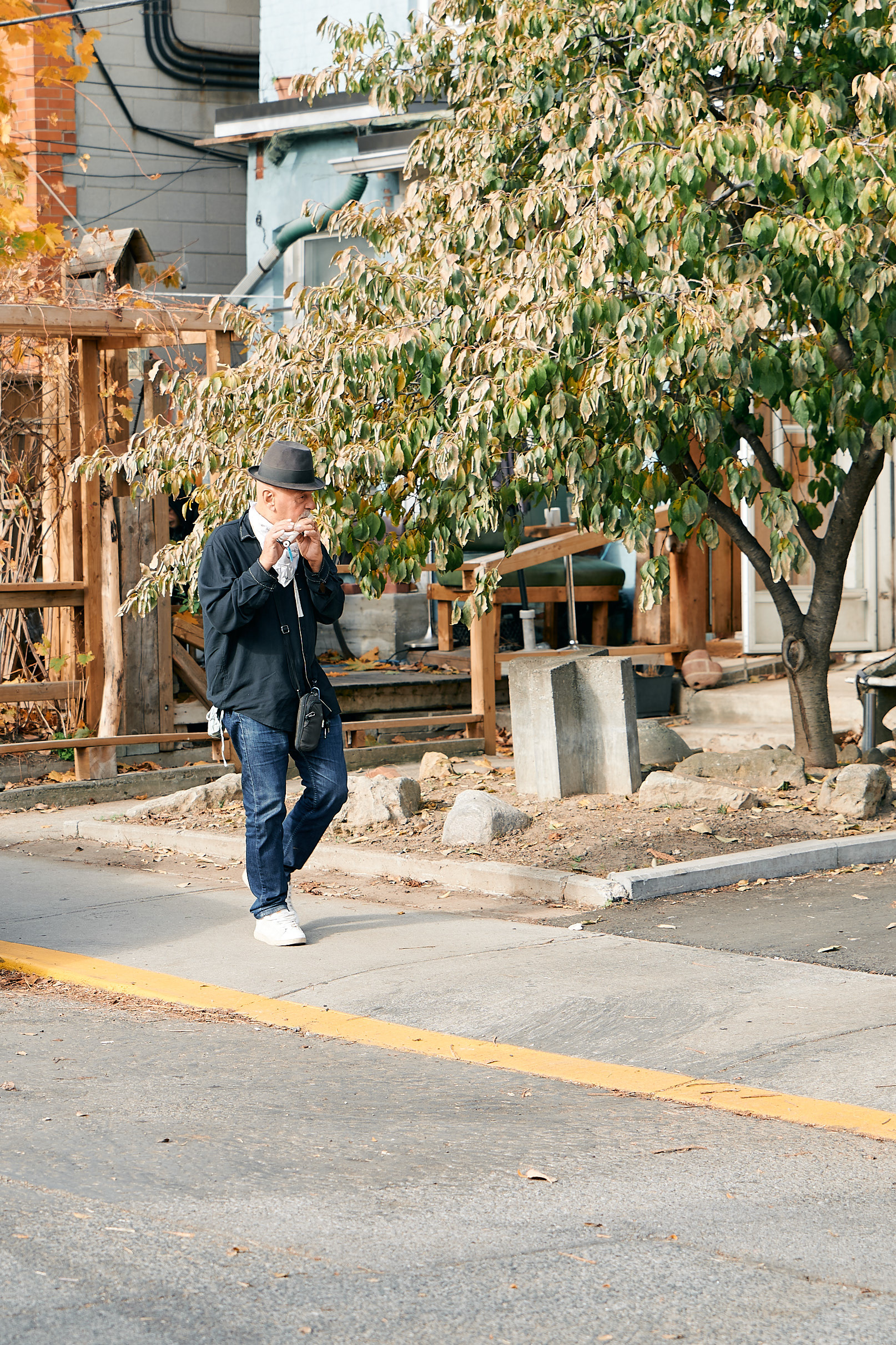 An older man casually strolling by while playing his flute is Kensington at its best