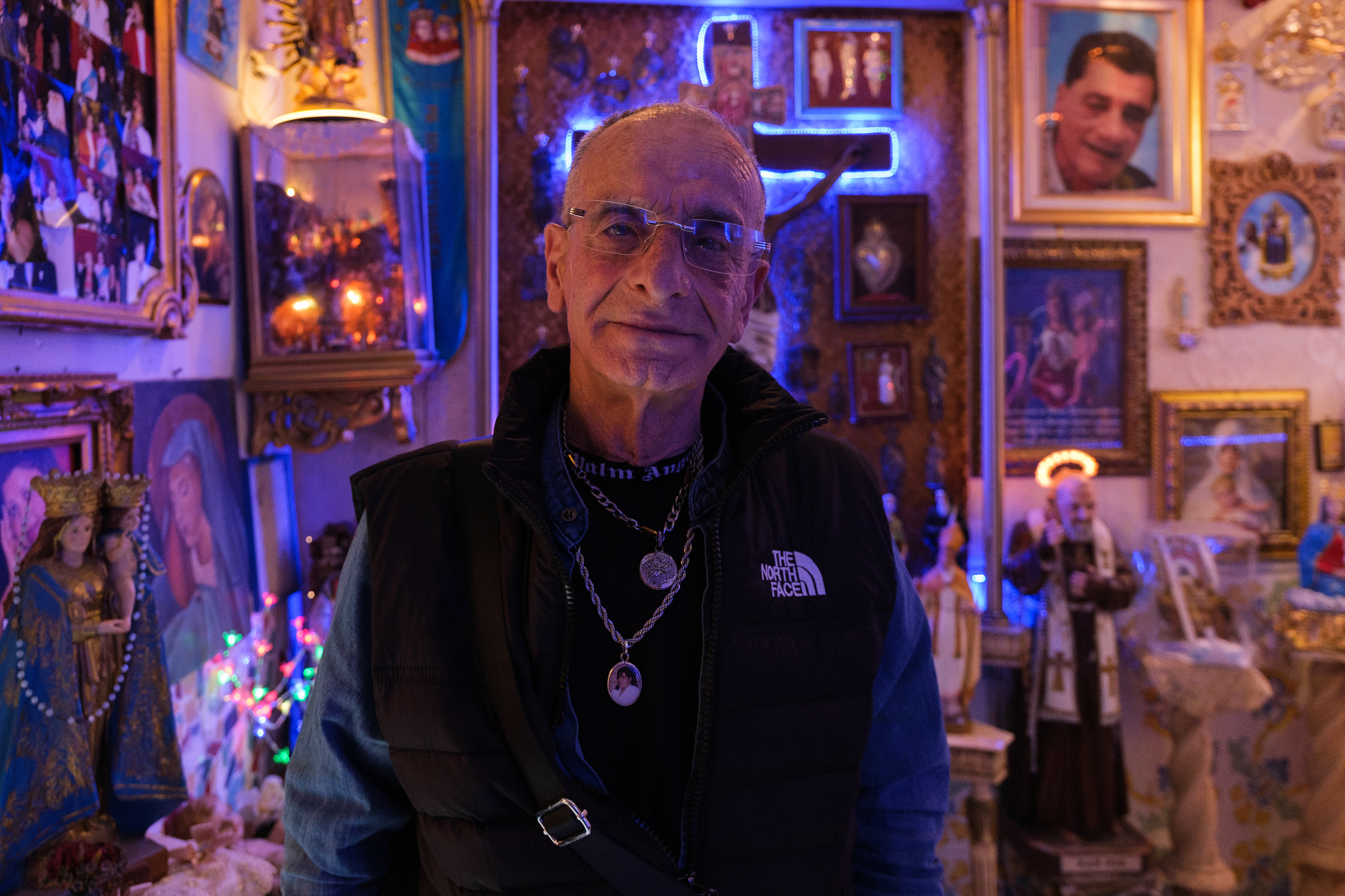 Naples (Italy): Resident Vincenzo Ziccardi stands inside the street chapel he transformed in the Rione Sanità district. Originally dedicated to his late wife, Maria, the sanctuary evolved into a shared community shrine honouring other deceased neighborhood residents.