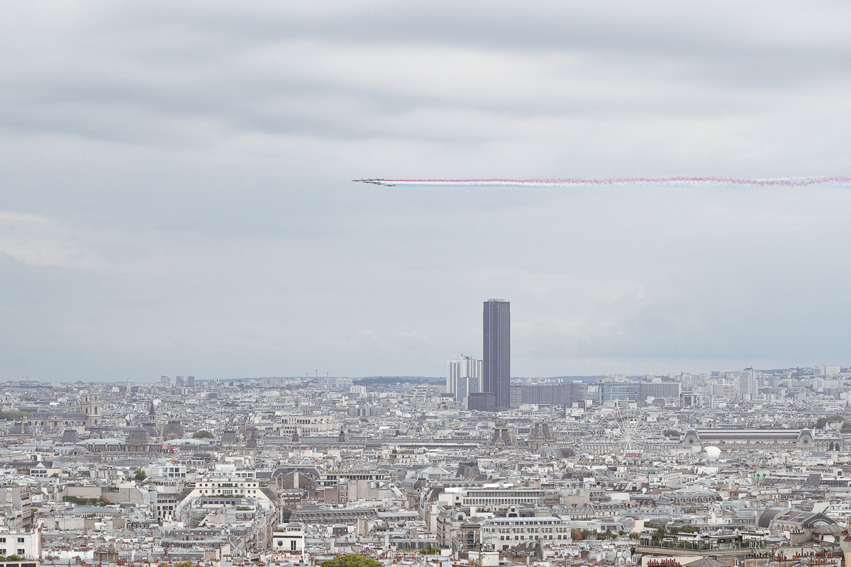 het peloton renners is aangekomen op de Champs-Élysé en wordt begroet door vliegtuigen van 'Patrouille de France' die de franse vlag 'uitstoten'