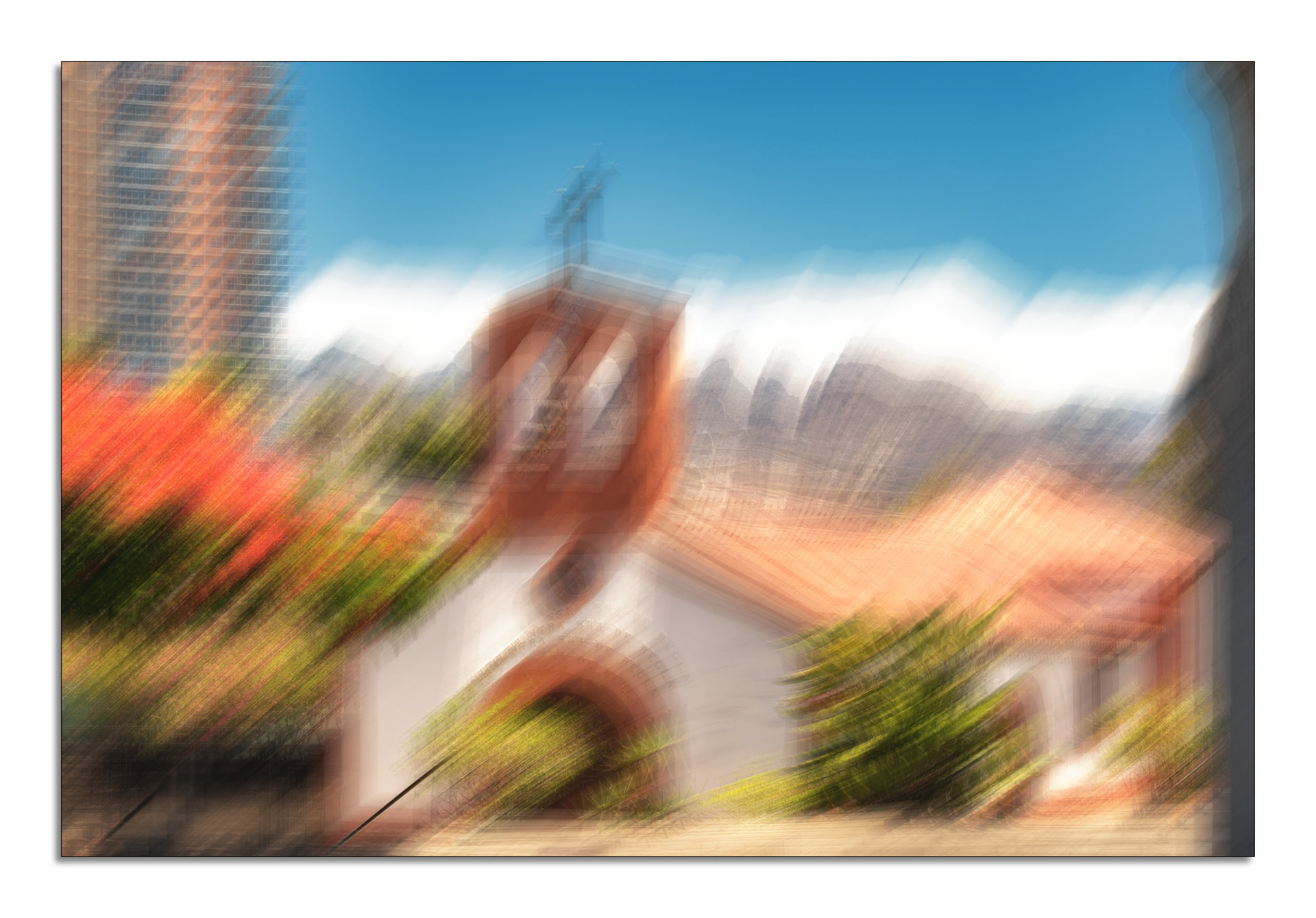 Ein abstraktes, mit beabsichtigter Kamerabewegung (ICM) erstelltes Foto, das den Blick auf eine Kirche fokussiert. Durch einen dynamischen Wirbel- oder Zoom-Effekt werden die Linien von der Bildmitte nach außen gezogen. Im Zentrum steht eine weiß getünchte Kirche mit einem Terrakotta-Glockenturm und einem Kreuz. Links davon ragt ein modernes Hochhaus in den blauen Himmel, kontrastiert von leuchtend roten Blüten im Vordergrund. Die Komposition erzeugt ein starkes Gefühl von Bewegung und stellt einen visuellen Kontrast zwischen traditioneller und moderner Architektur her.  -  #icm_photography #intentionalcameramovement #abstraktefotografie #fotokunst #architekturfotografie #kontraste #altundneu #traditiontrifftmoderne #kirche #bewegungsunschärfe #creativephotography #artofvisuals #zoomburst #impressionistisch #dynamik