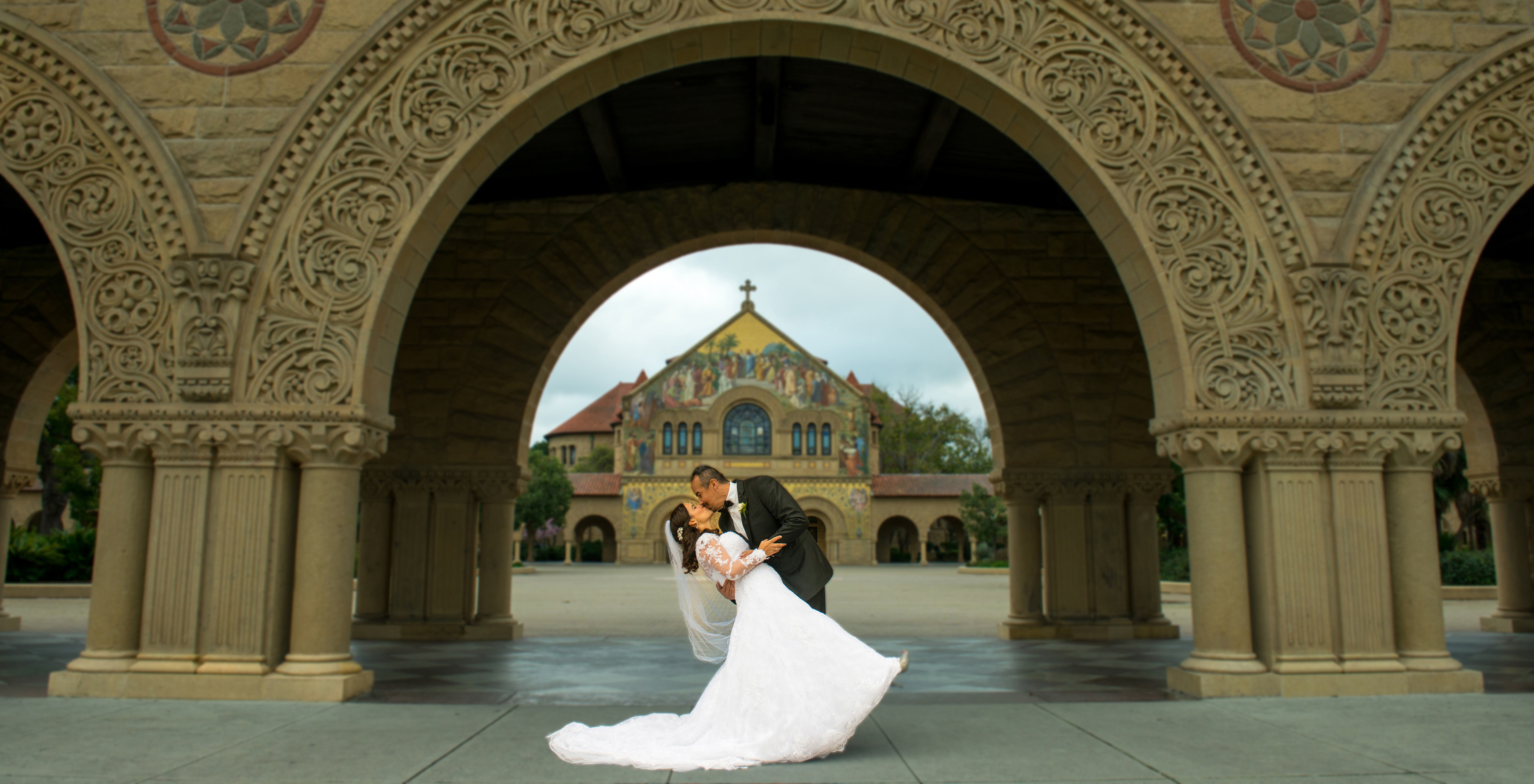 Elegant wedding photo of a bride and groom at the Legion of Honor in San Francisco, framed by neoclassical columns.