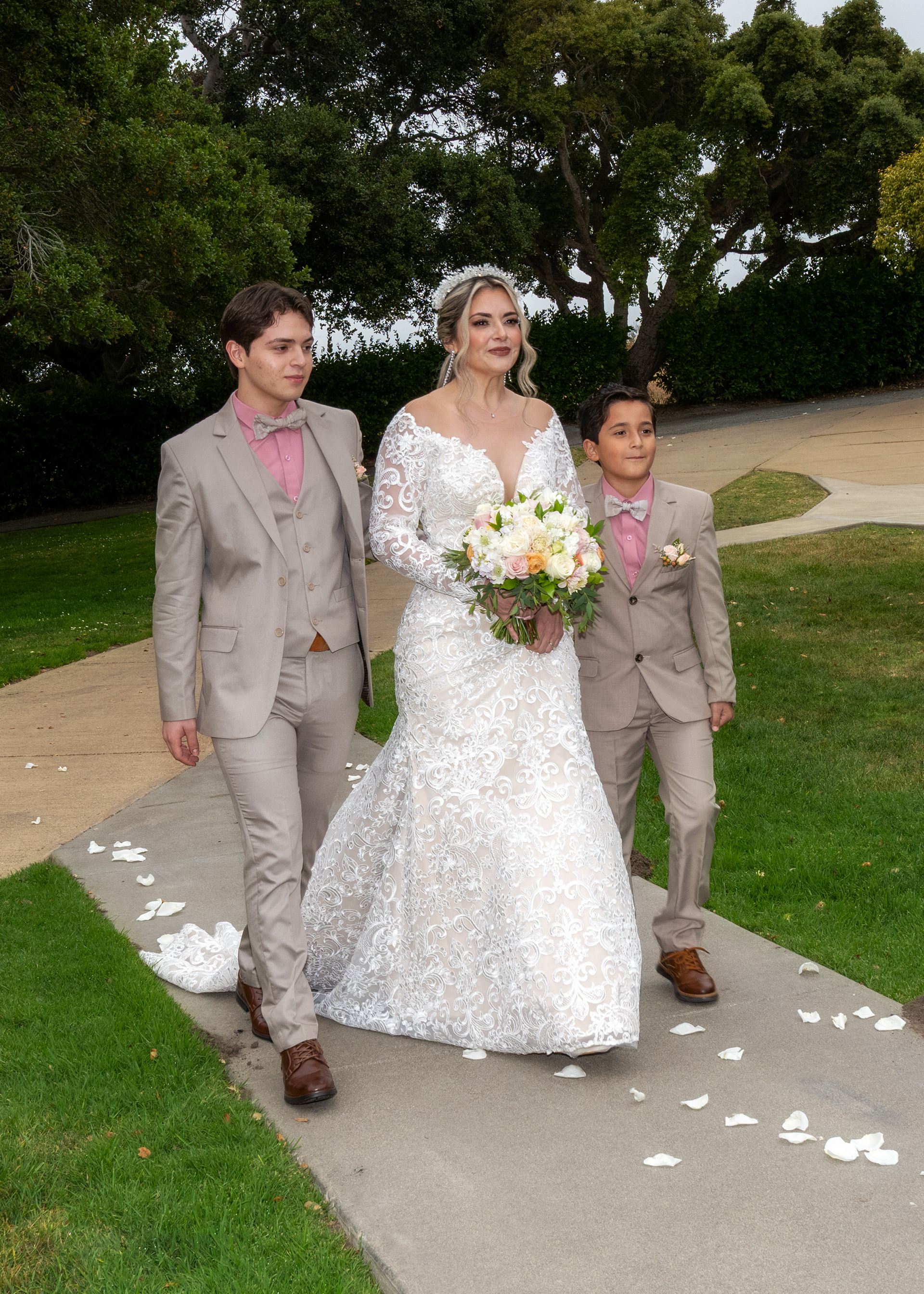 The bride, escorted by her two young sons, during a heartfelt ceremony at Carmel Fields by Wedgewood Weddings, captured by Monterey Photography — a timeless moment in Carmel Valley.