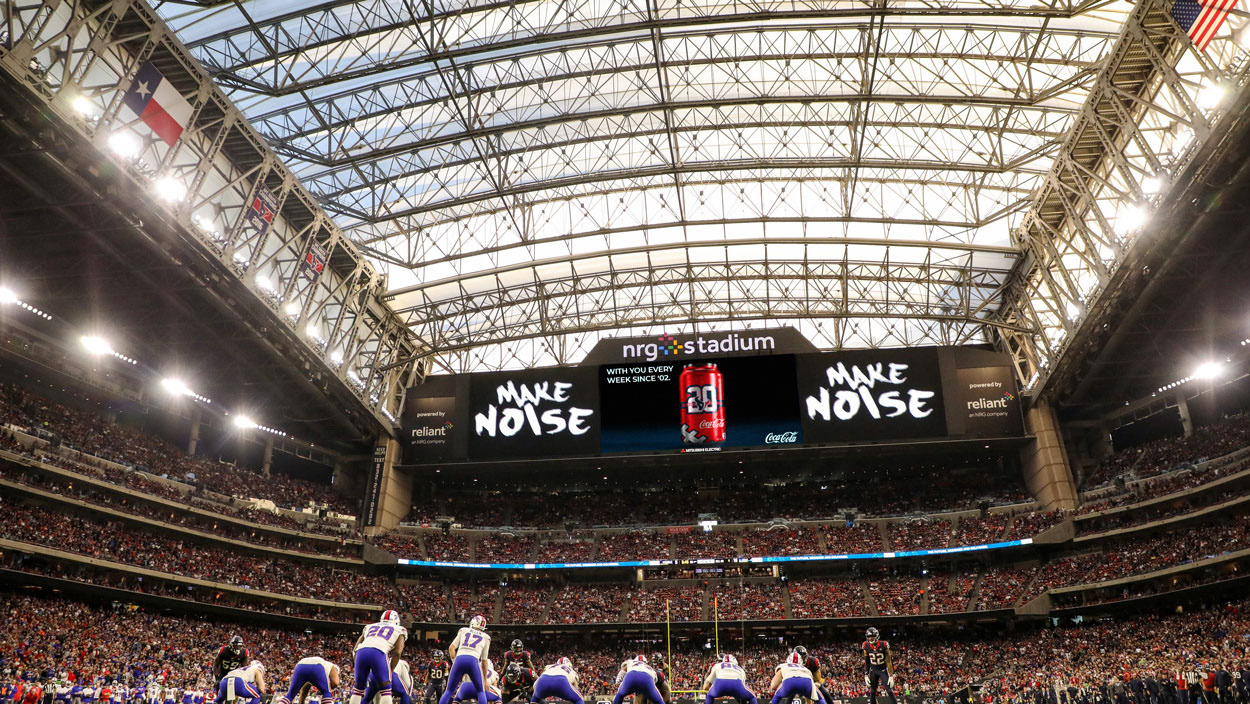 Texans game featuring Coca-Cola collector can billboard.