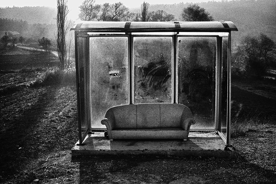 A seat left at a minibus stop on a village road