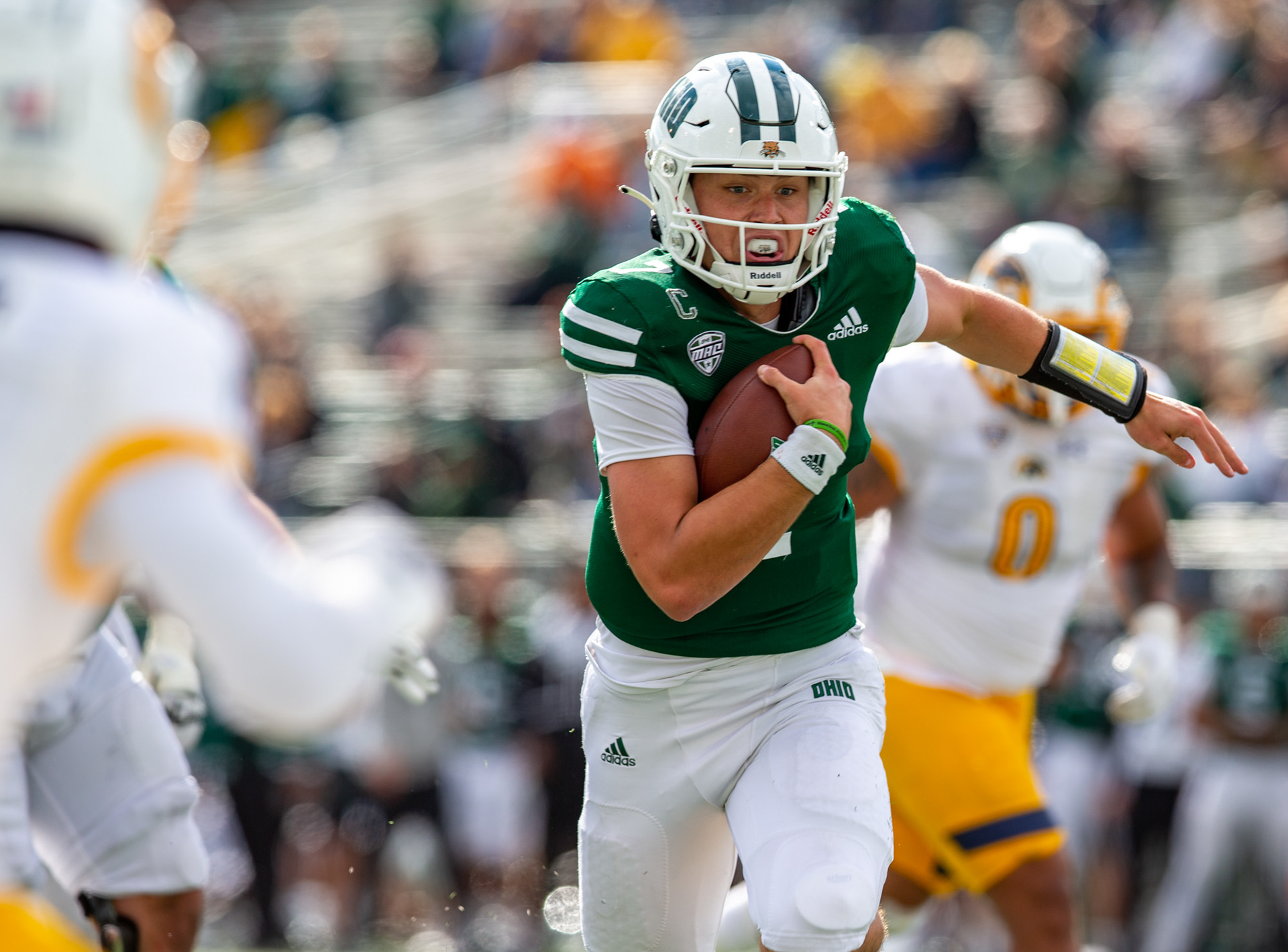 Ohio Quarterback Kurtis Rouke runs past Kent State defense in Athens, Ohio.