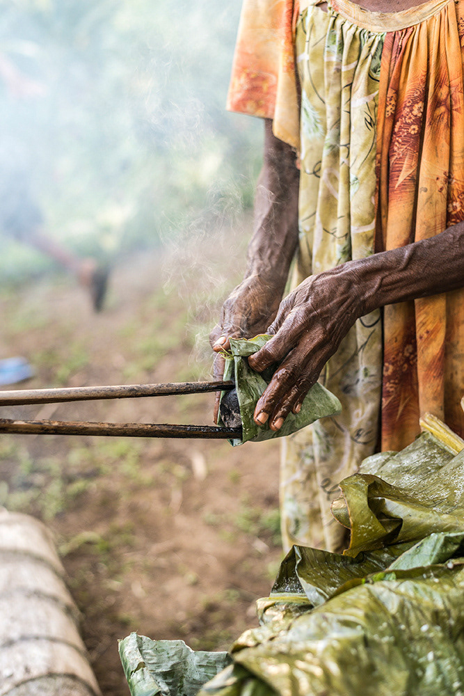 Traditional Haigir, Cooking with coconut, herbs, chicken & hot stones (Hot stones from the fire are wrapped in Banana Leaves before adding to the Haigir)