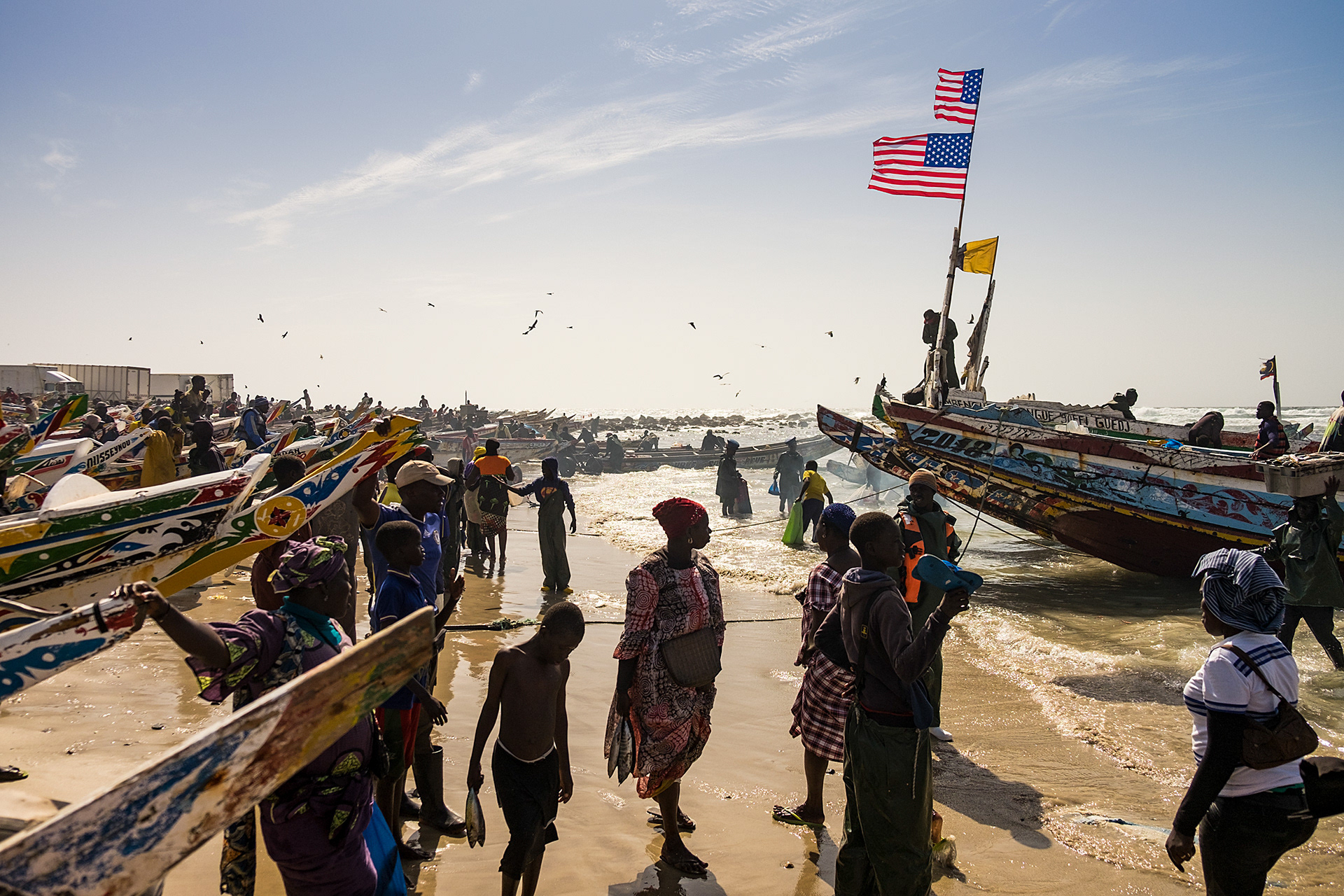 It's a hive of activity as the fishing fleet returns with the days catch at Yoff fishing beach