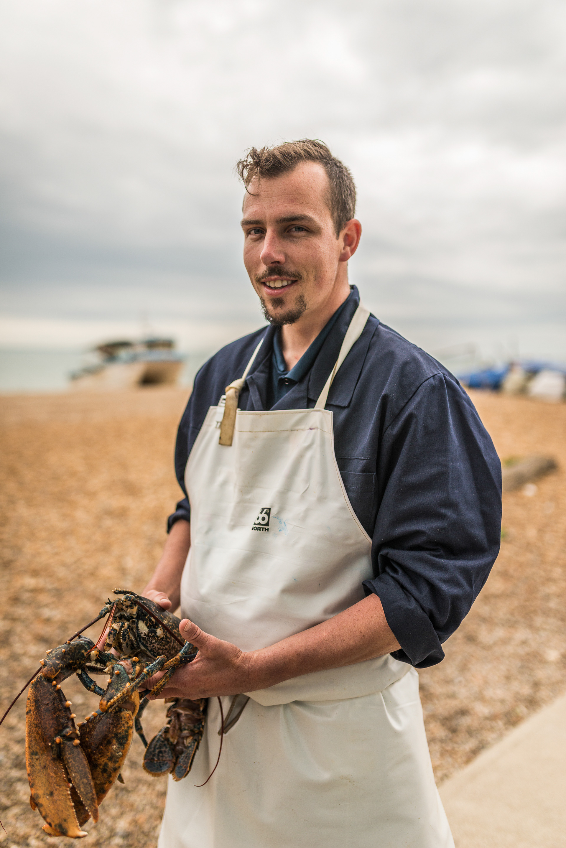 Dan with a locally caught live lobster at Griggs fishmongers on the beach at Hythe, Kent
