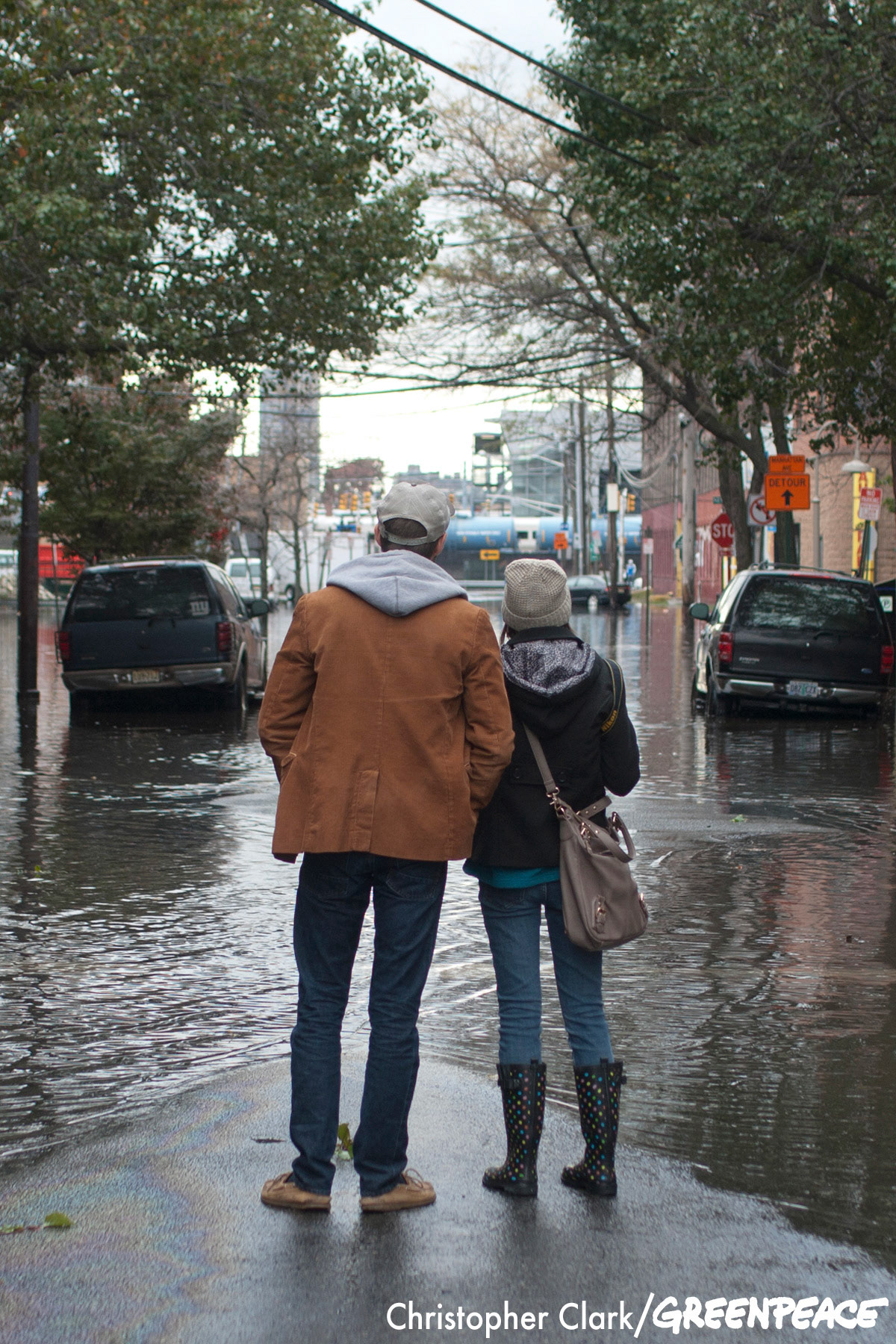 A couple stands on a patch of dry land and surveys the flooded streets of Hoboken, New Jersey in the aftermath of hurricane Sandy on October 31st, 2012.