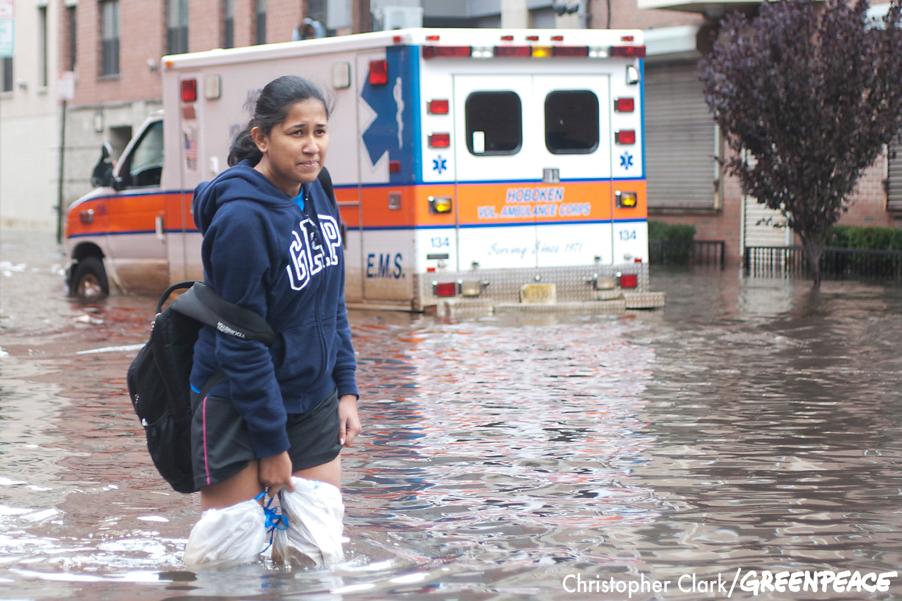 A woman holds onto makeshift waiters as she walks through the flooded streets of Hoboken, New Jersey in the aftermath of hurricane Sandy on October 31st, 2012.