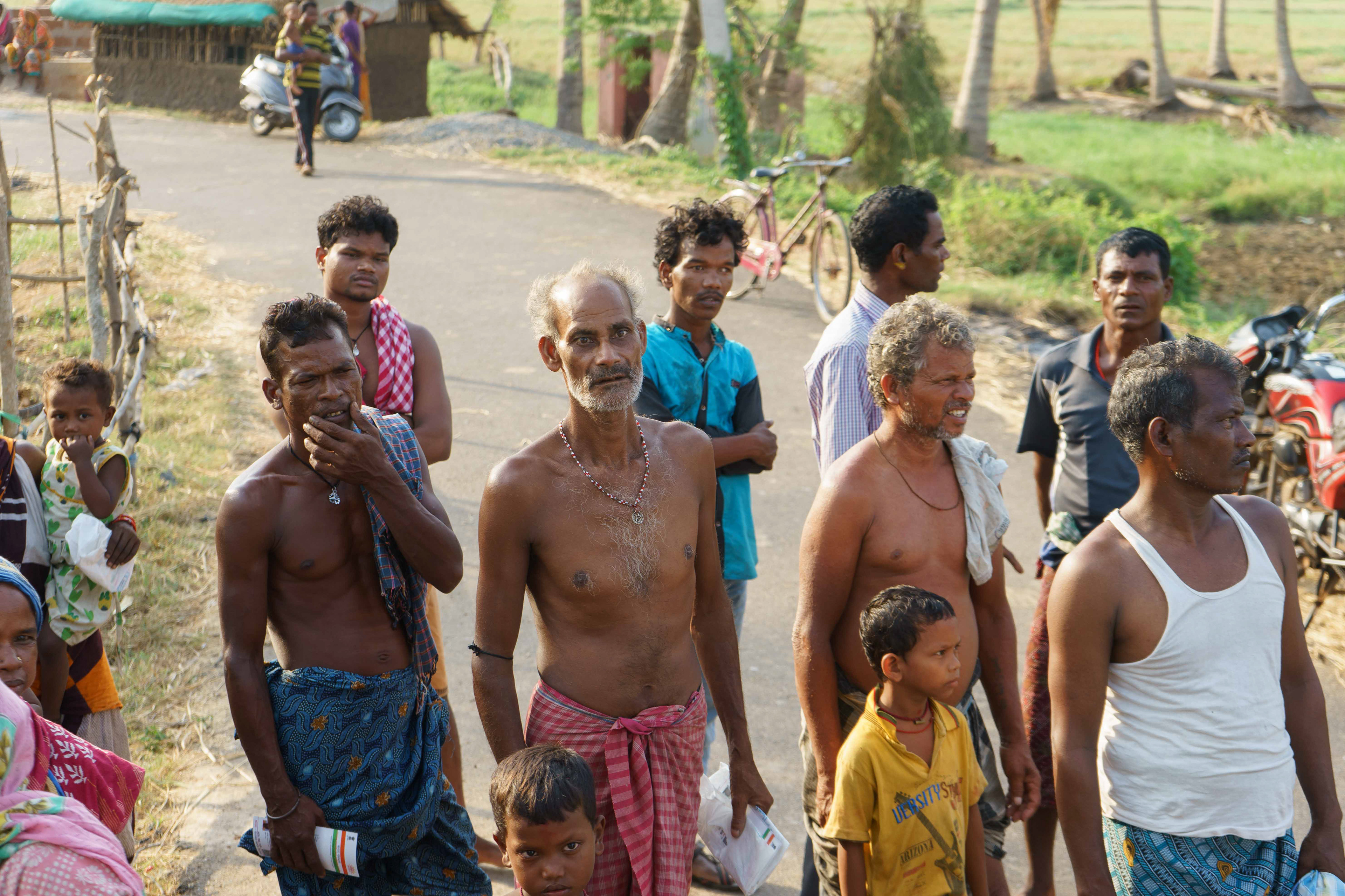 Men of the harijan community (a term they refer to themselves by) await their turn with Aadhaar card in hand to collect the relief.