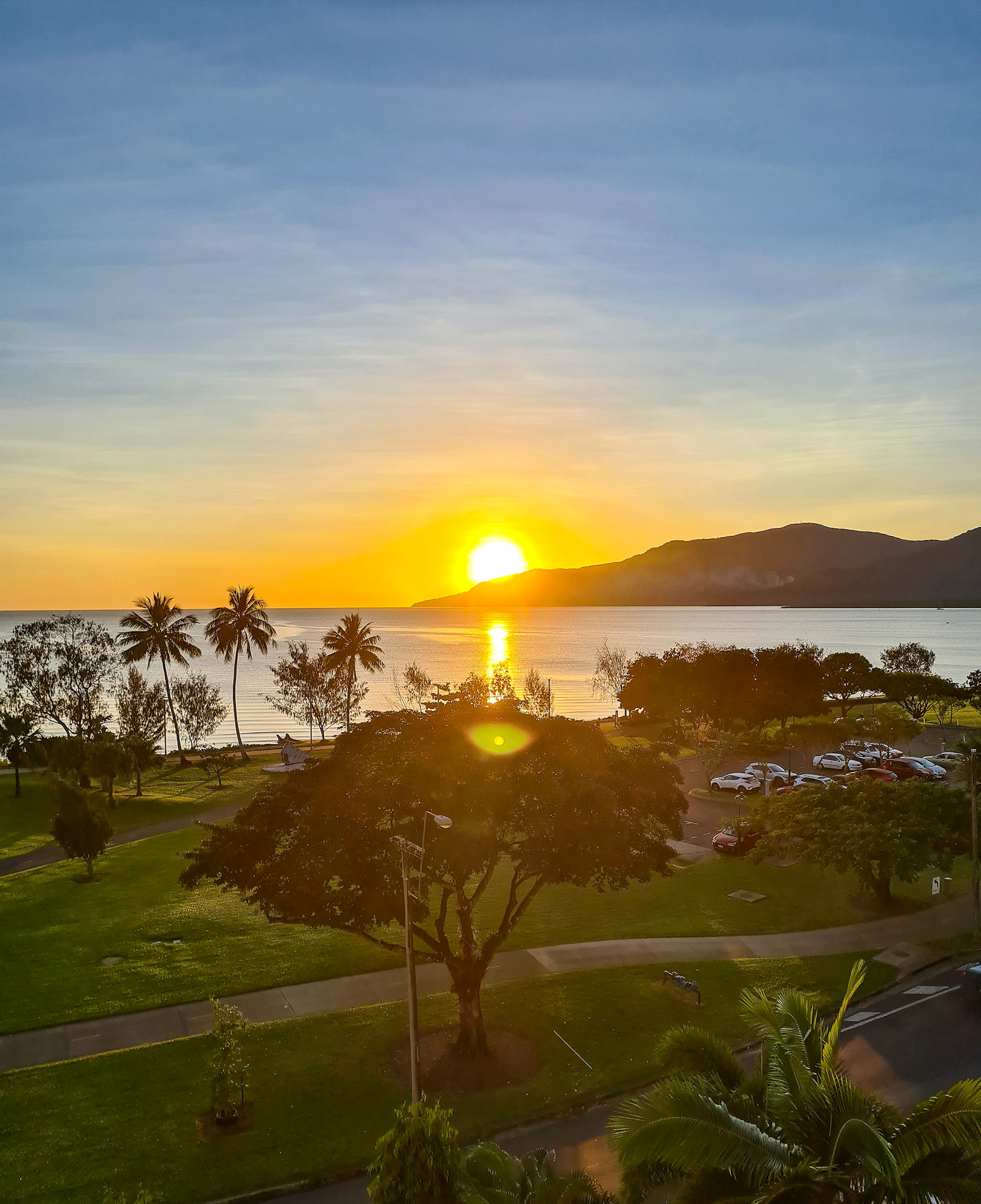 Sunrise beam across Cairns harbour glow on a tropical Cairns North the Esplanade Queensland Australia© copyright lewis a collins ! http://lewiscollins.au