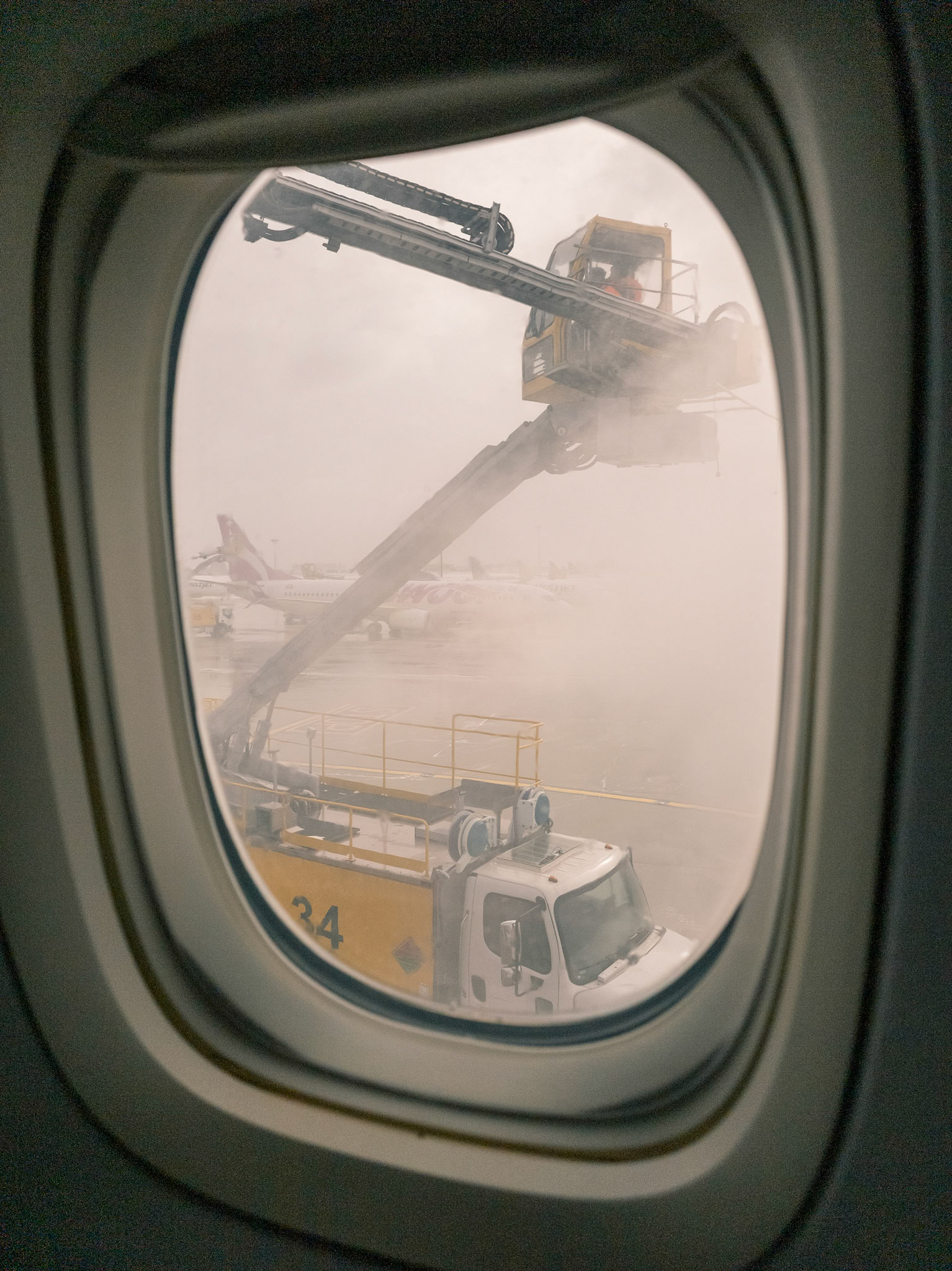 2025 november looking out plane window at deicing plane preparing to fly airbus a319-100 quebec toronto canada