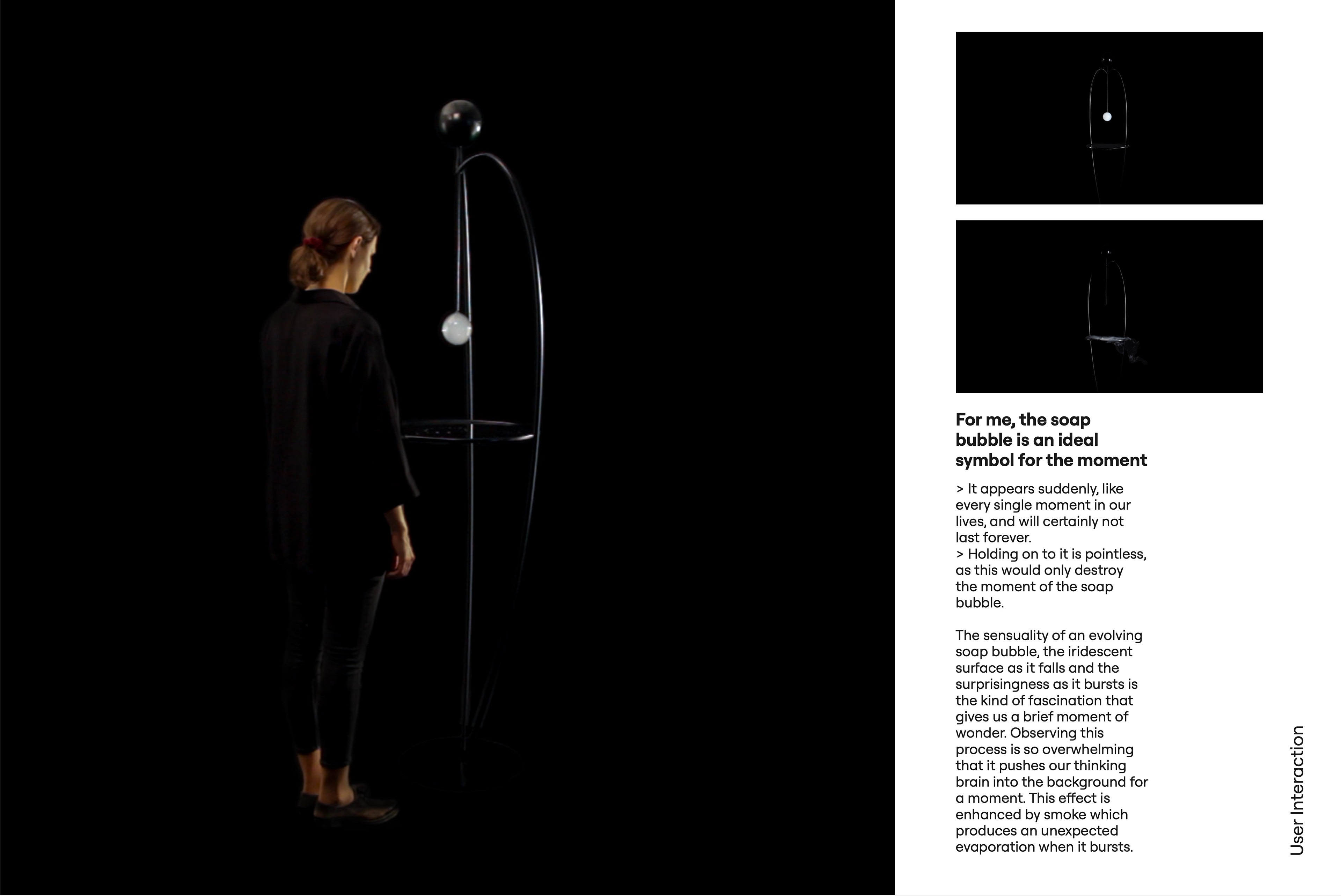User Interaction. A woman stands next to the object and looks at the soap bubble hanging below its spherical head; two small photos show the object in the dark, once with a glowing bubble and once with smoke spreading over the platform. Text: For me, the soap bubble is an ideal symbol for the moment. It appears suddenly, like every single moment in our lives, and will certainly not last forever. Holding on to it is pointless, as this would only destroy the moment of the soap bubble. The sensuality of an evolving soap bubble, the iridescent surface as it falls and the surprisingness as it bursts are the kind of fascination that gives us a brief moment of wonder. Observing this process is so overwhelming that it pushes our thinking brain into the background for a moment. This effect is enhanced by smoke, which produces an unexpected evaporation when the bubble bursts.