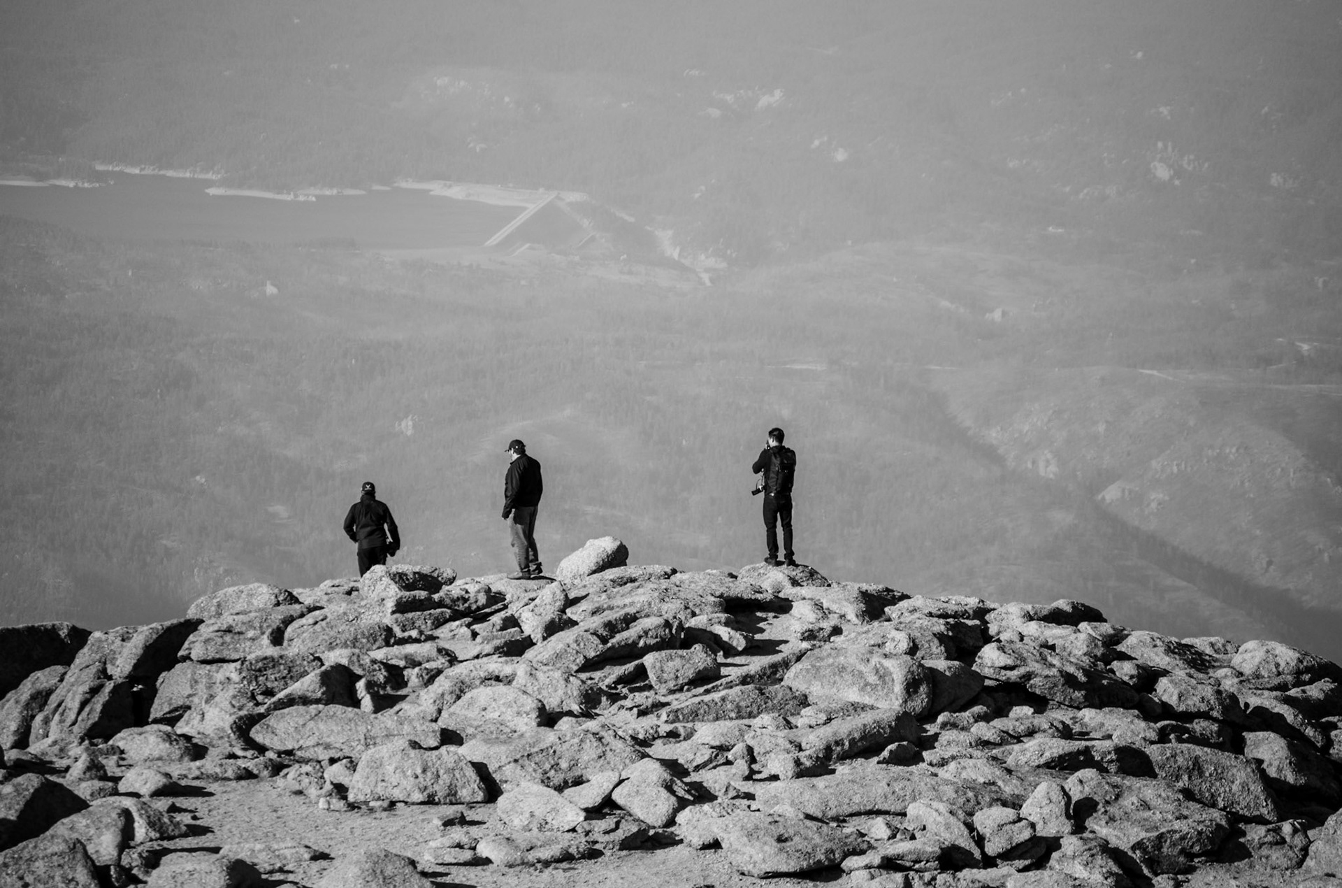 Three men look out over Eastern Colorado from the summit of Pikes Peak at an elevation of 4,302 meters.