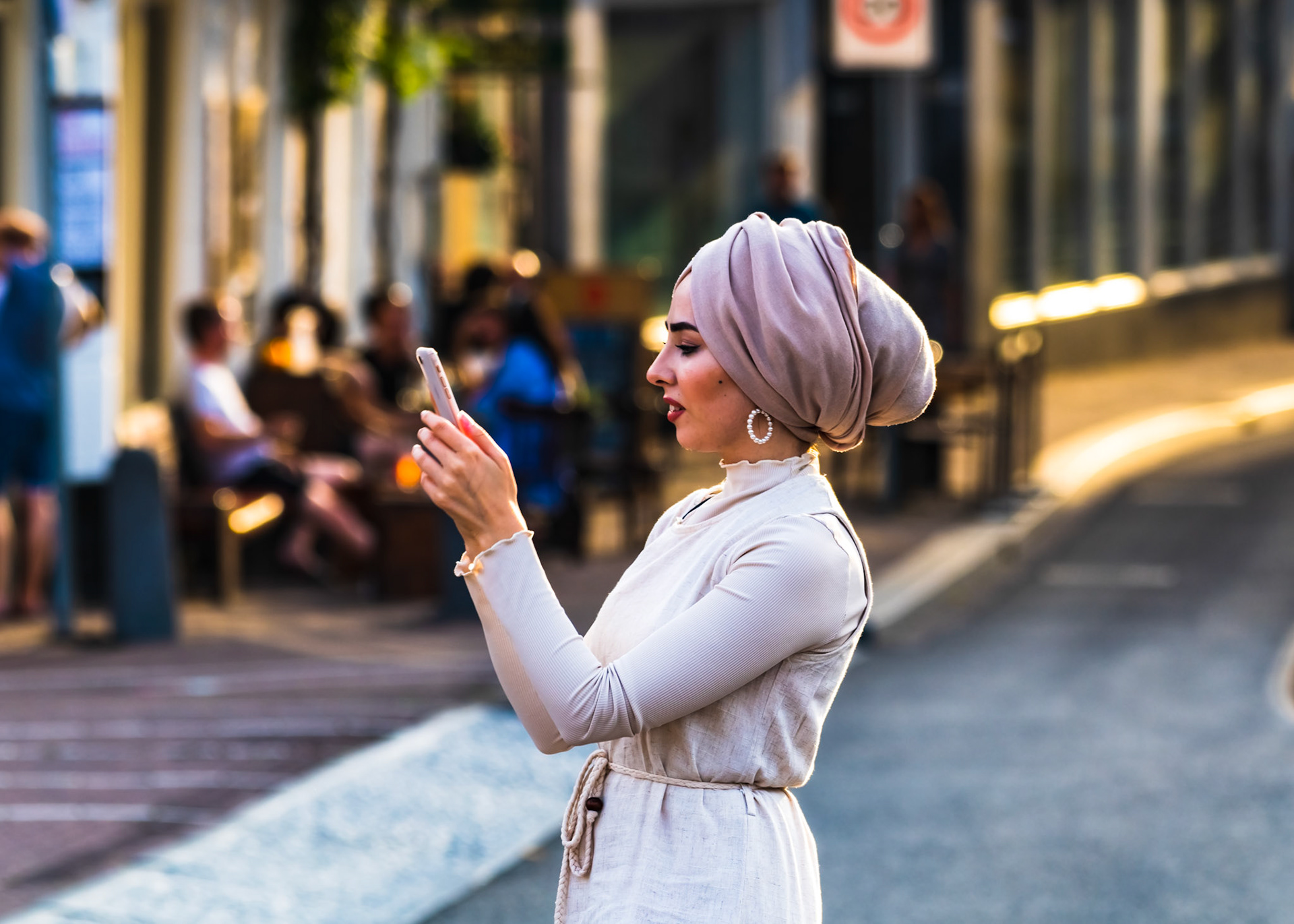 A young woman composs a photo of Magere Brug, from Blauw Brug, Amsterdam