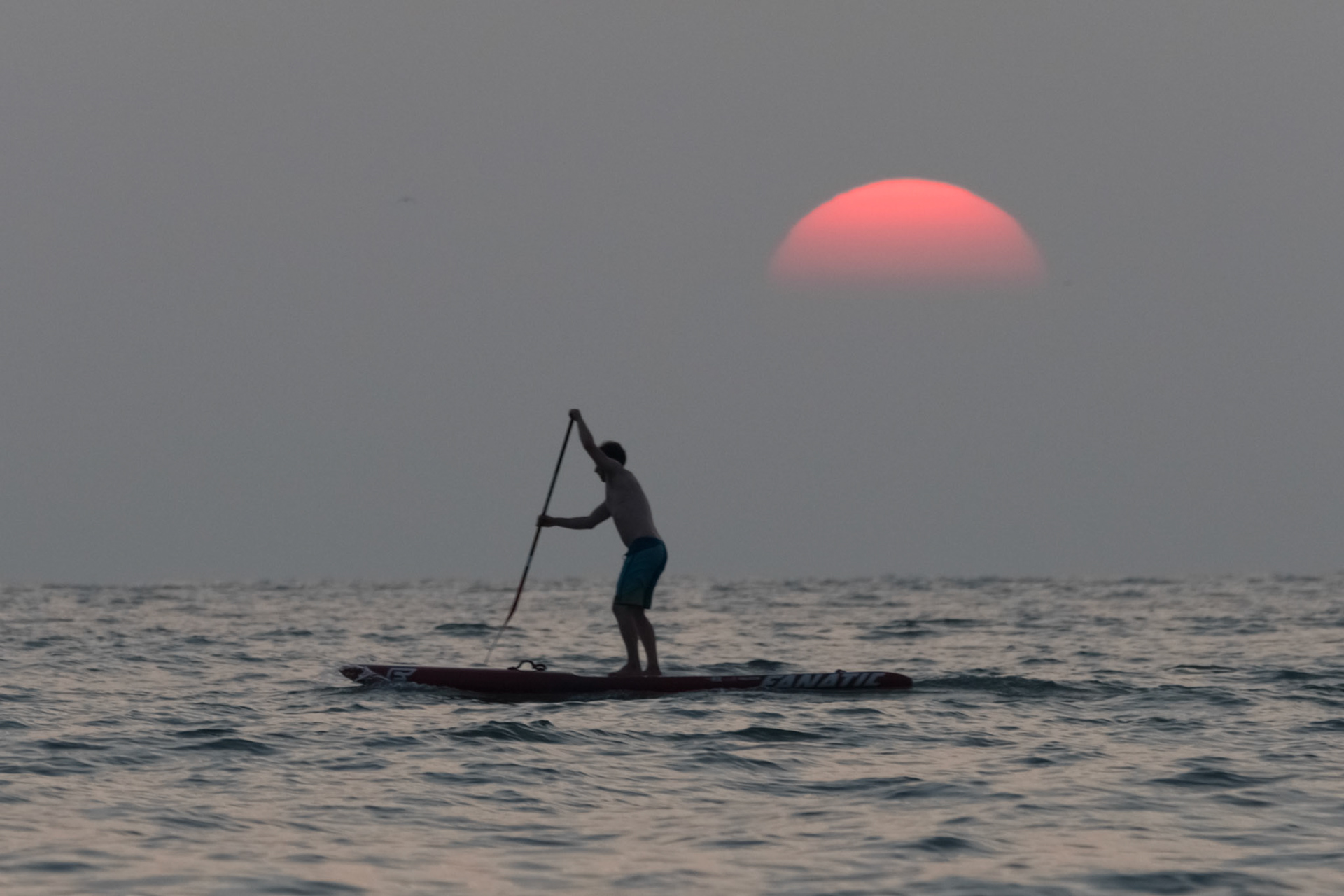 A padel boarder crosses the setting sun just after 22:00 in Scheveningen