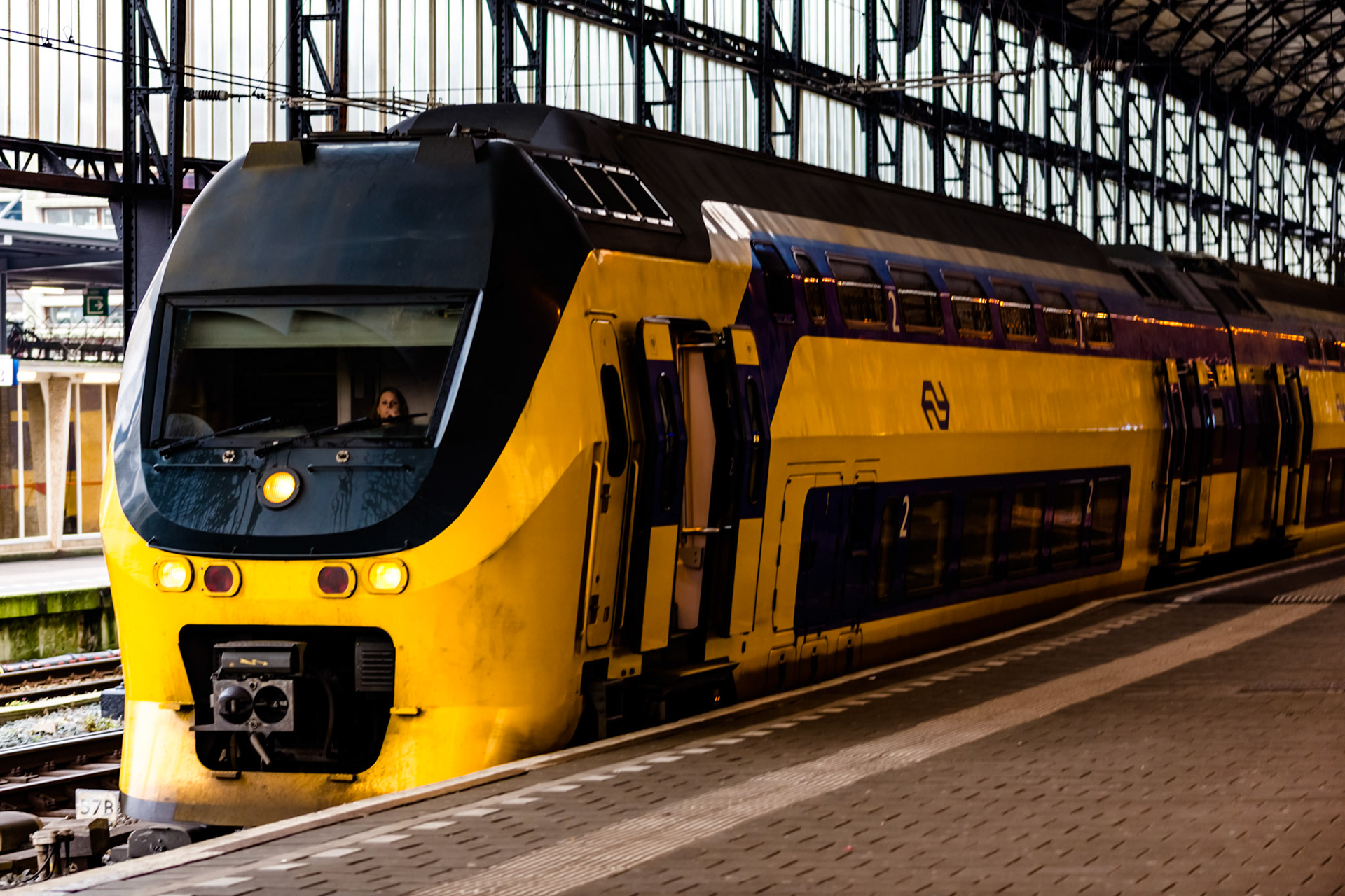 A train conductress prepares to depart Amsterdam Centraal Station for Haarlem