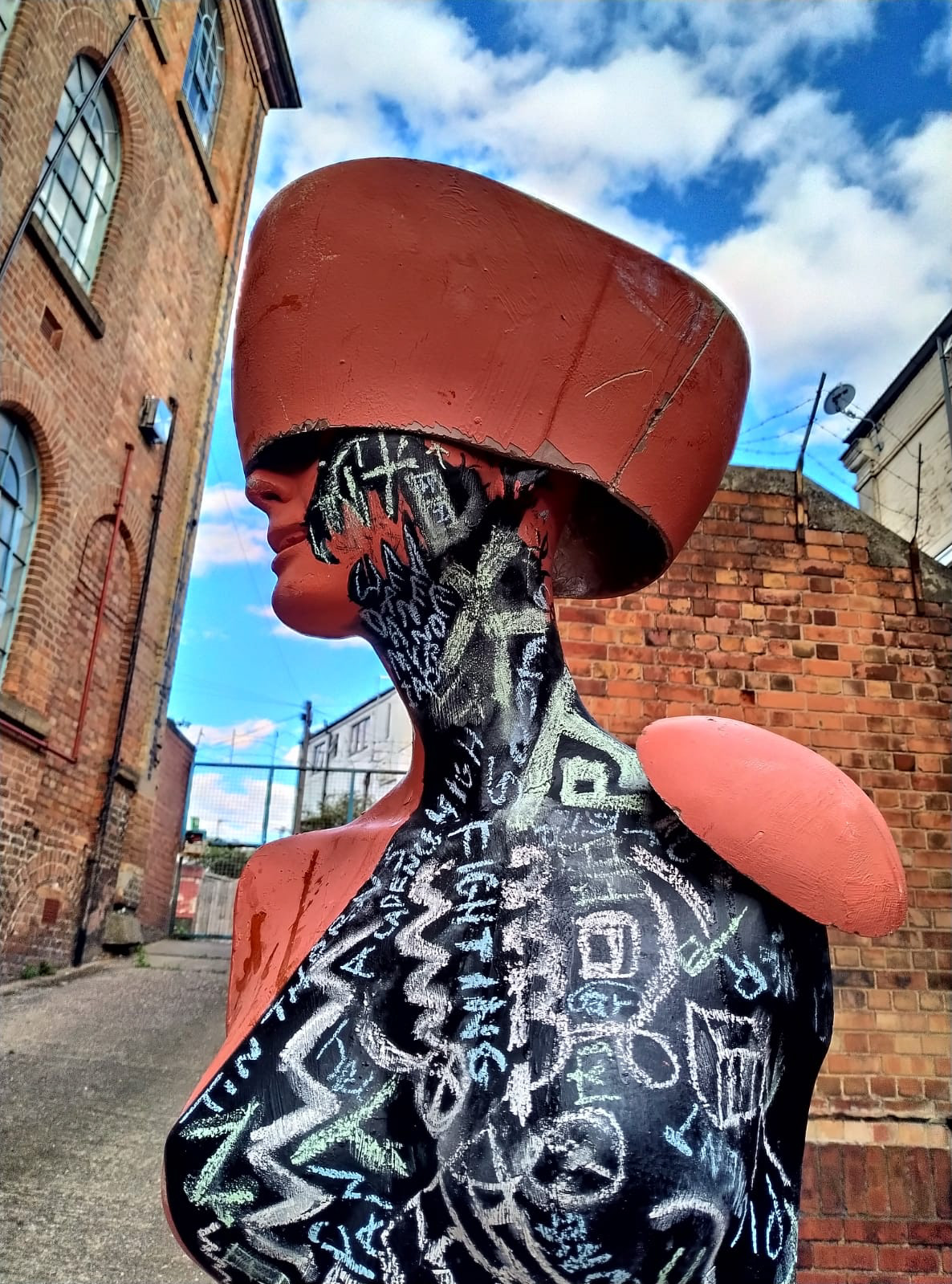 Two close up shots of Quick's work Marginalia. We see up close details showing chalk markings inscribed on the mannequin from the bottom of the torso to the side of the face.