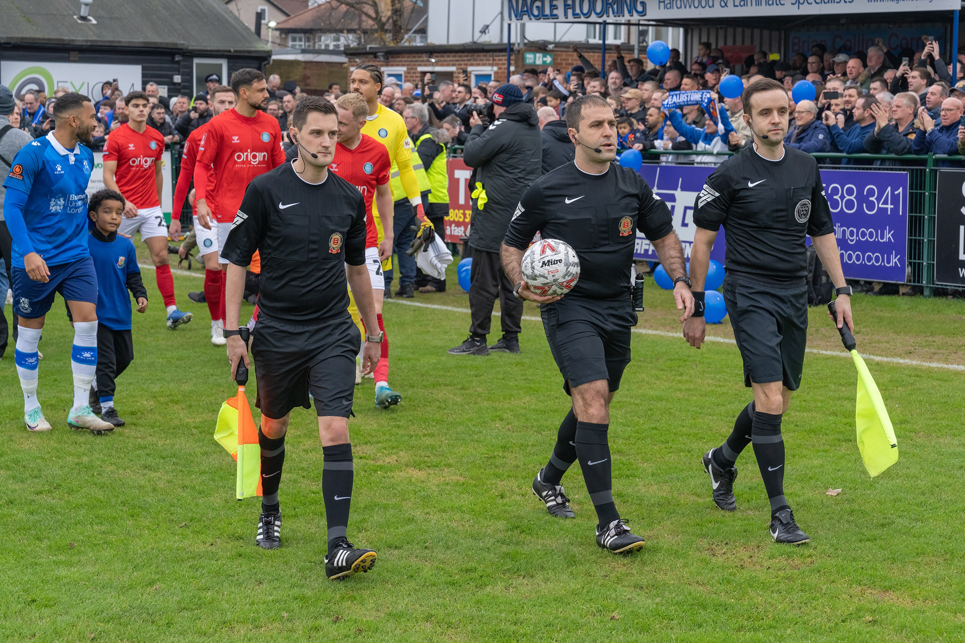 Officials lead out the teams