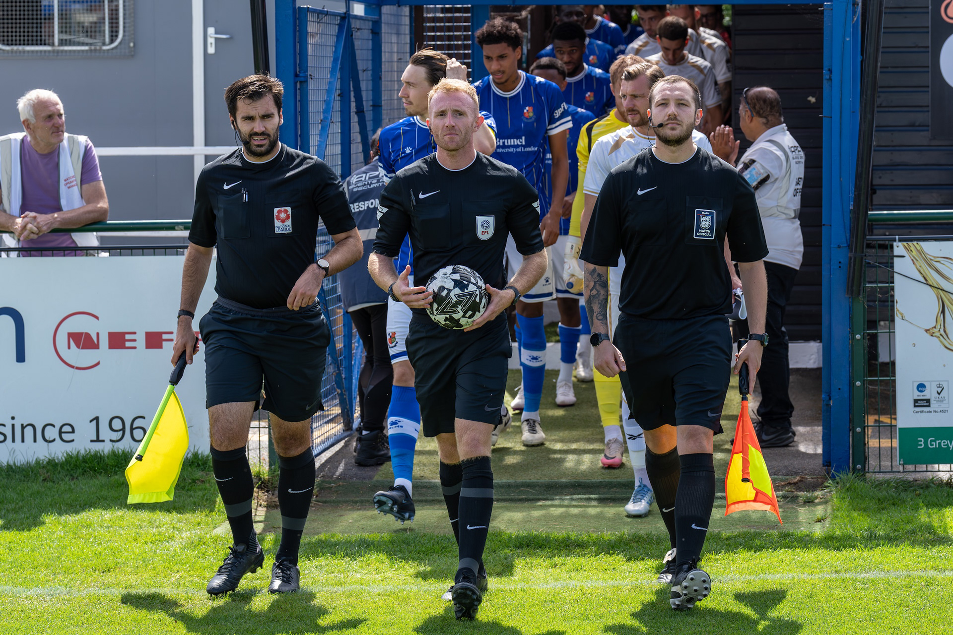 Officials lead out the teams