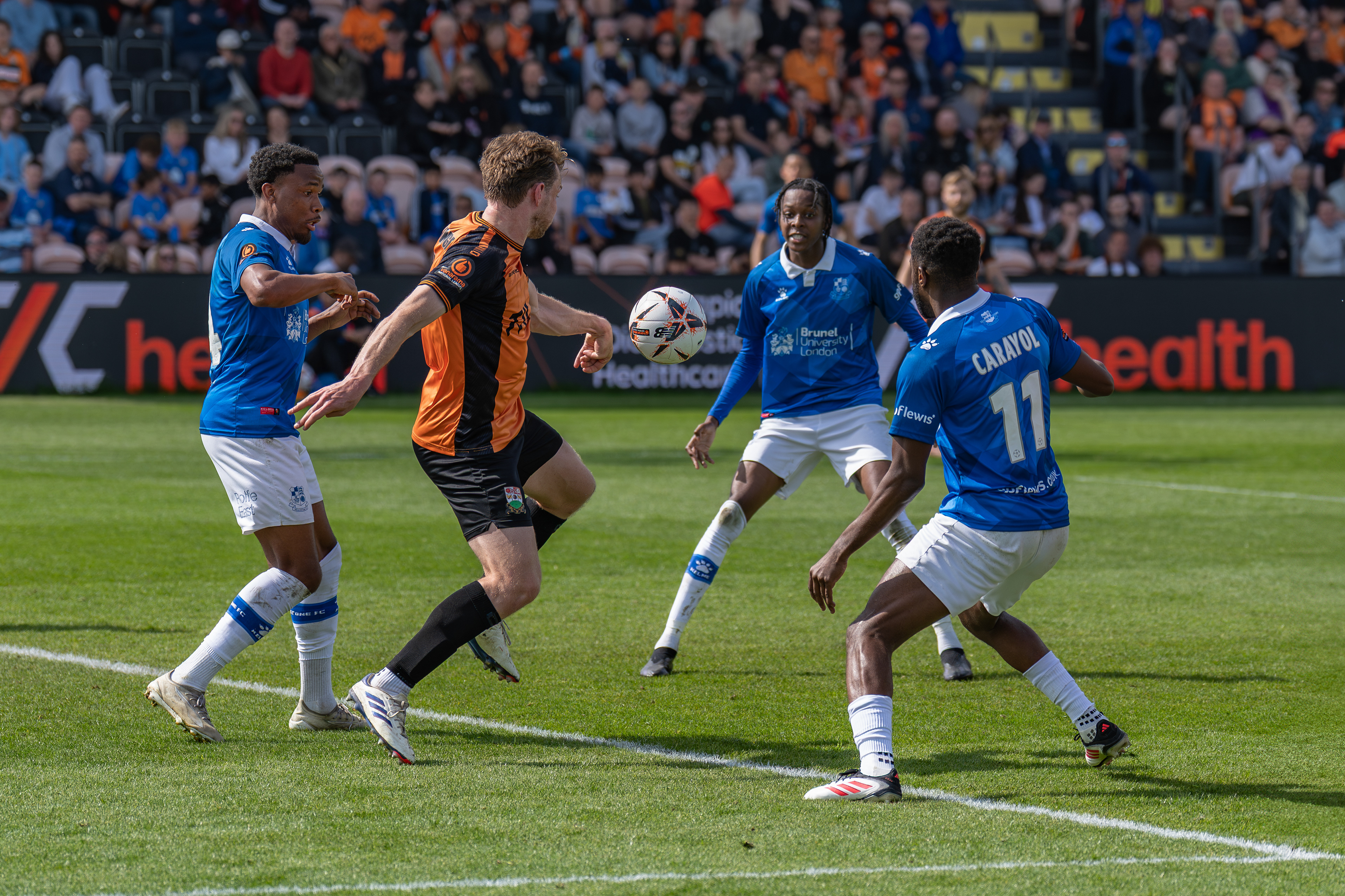 Bees defender Collingne under pressure punches the ball away......