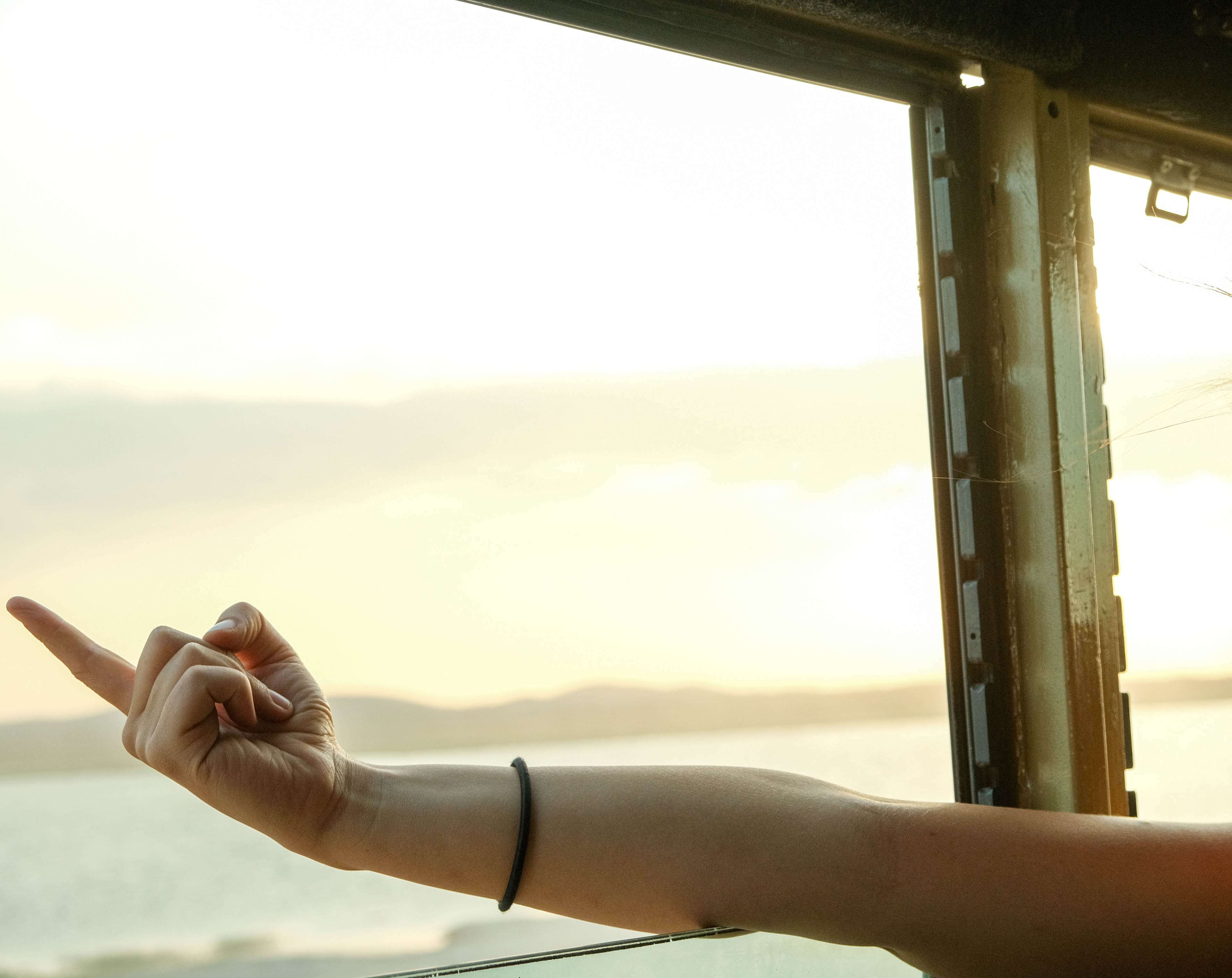 Hand pointing out the window