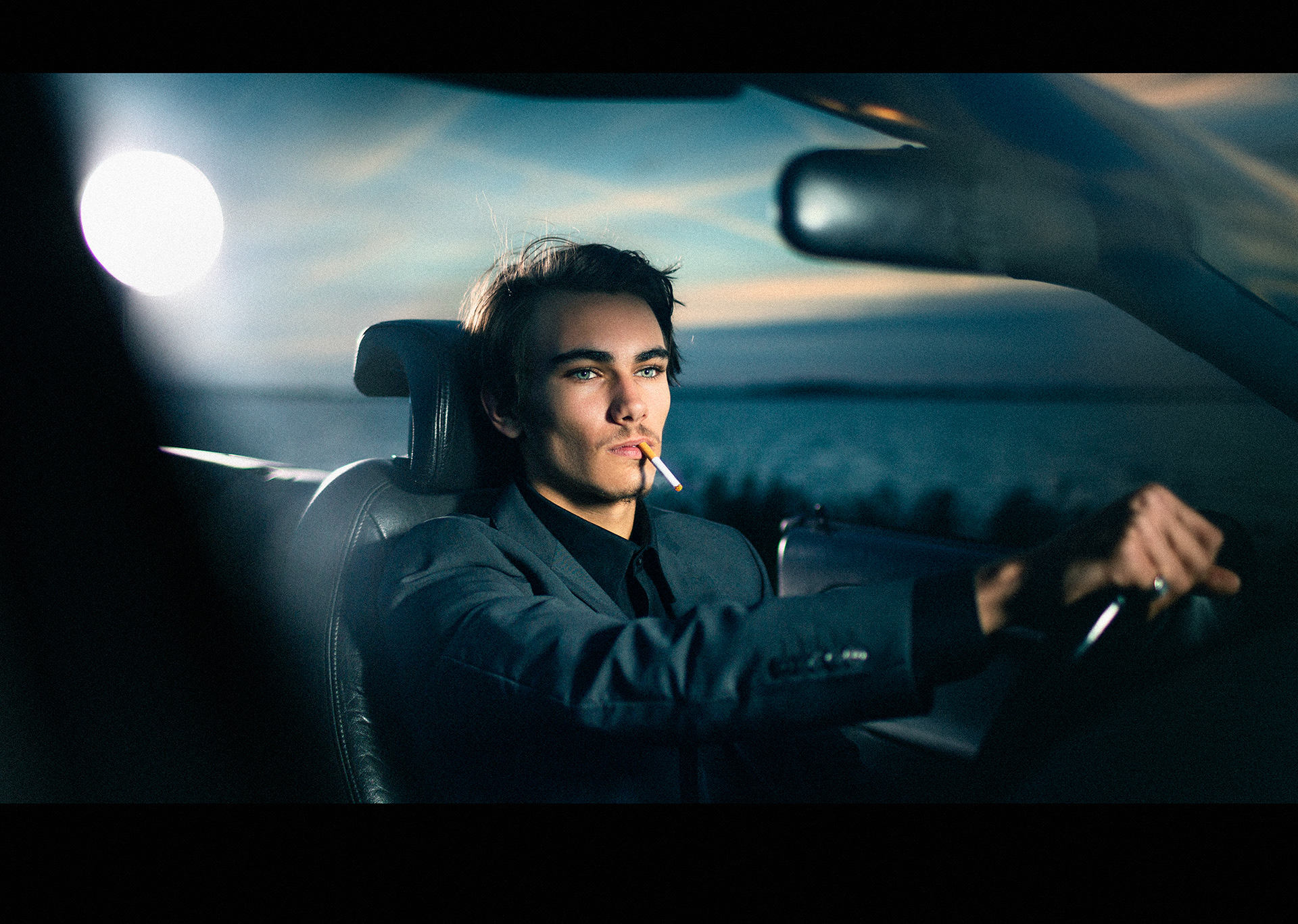 Portret van mannelijk model in avondlucht bi cabrio door Joshua Rood fotografie