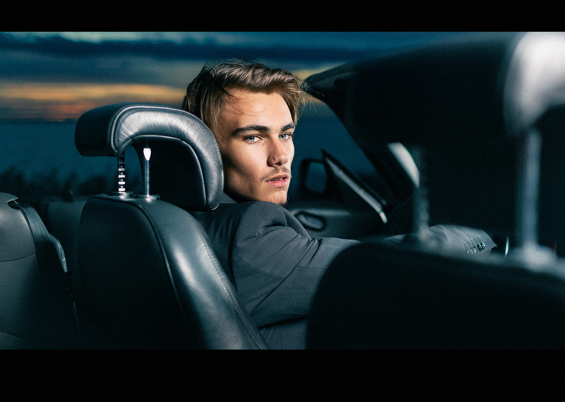 Portret van mannelijk model in avondlucht bi cabrio door Joshua Rood fotografie