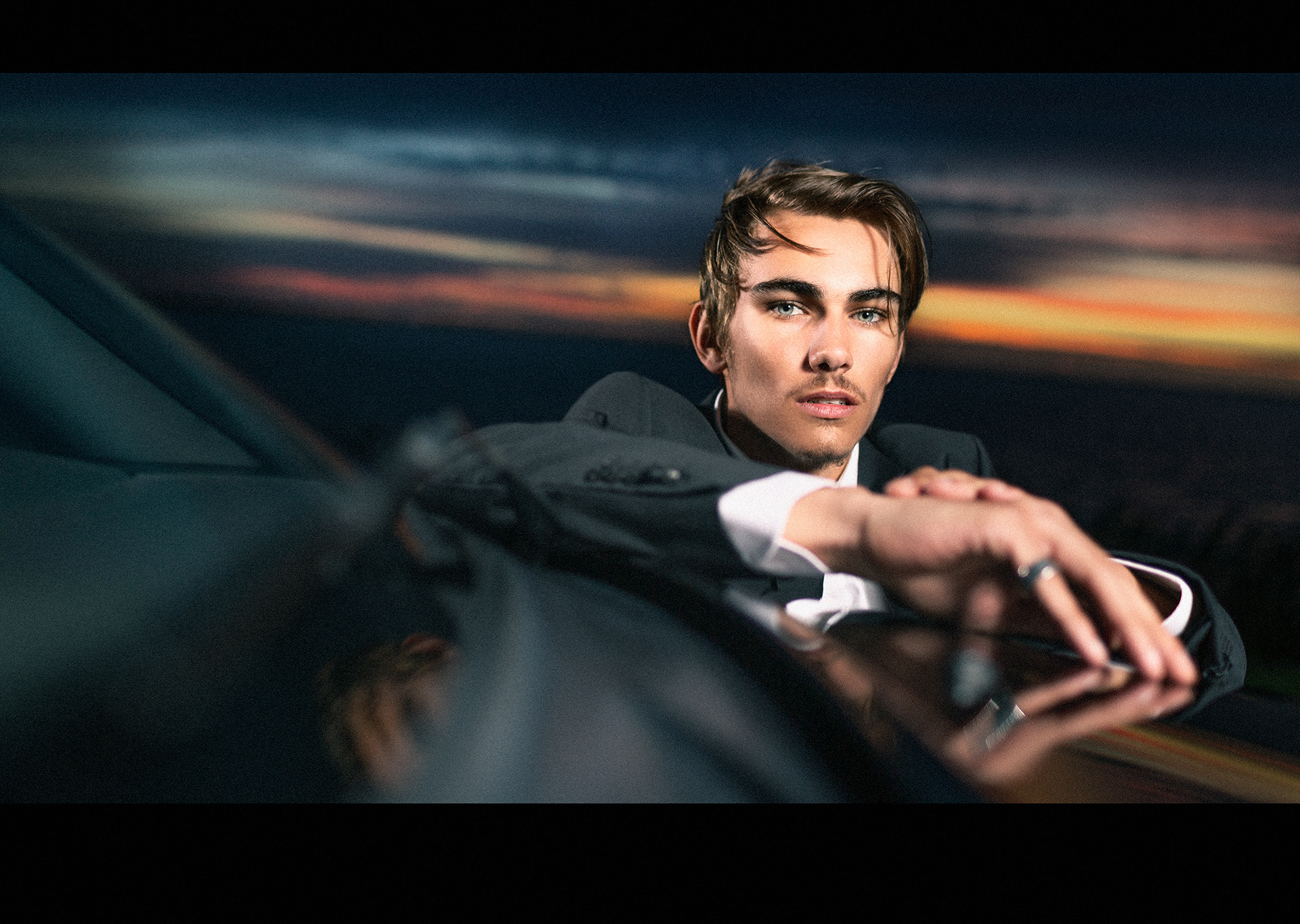 Portret van mannelijk model in avondlucht bi cabrio door Joshua Rood fotografie