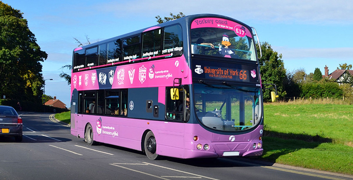 Livery and design for University of York Fist Bus number 66. Pink and purple with graphics and illustrations.