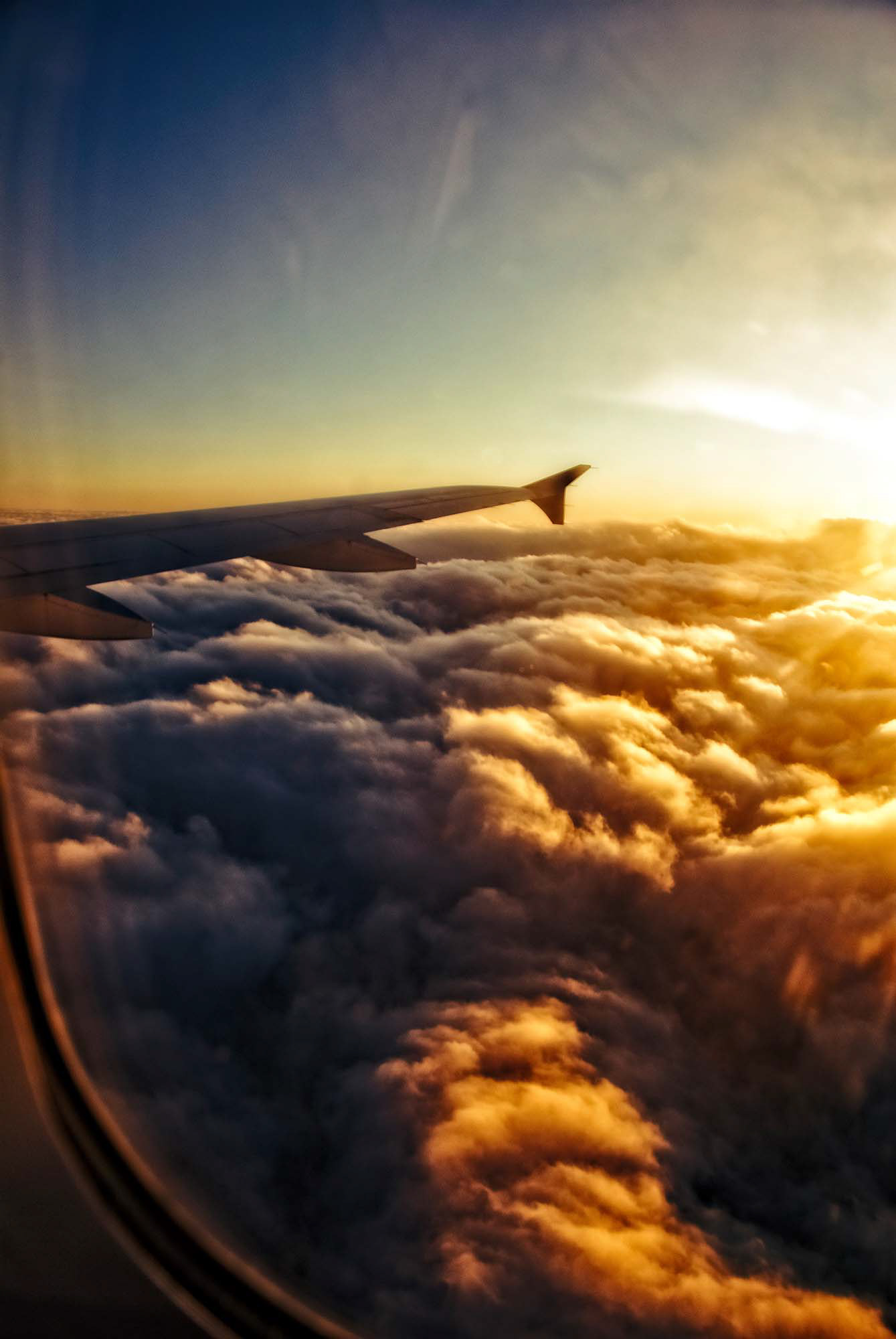 Malerischer Blick aus dem Kabinenfenster eines Flugzeugs auf eine Wolkendecke im Sonnenuntergang. Fotograf Klaus Ohlenschläger - Frankfurt - Bad Homburg – Kronberg