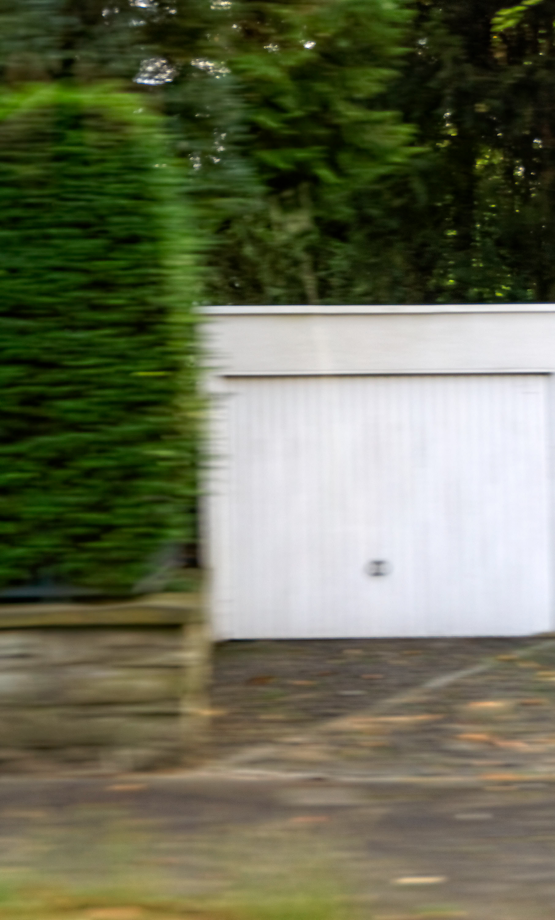 Einfahrt mit Garage - Ein Wohngebiet im Speckgürtel der Stadt. Ein kurzer Blick während der Fahrt durch die 30er Zone. Bürgerlich, ordentlich, adrett und gepflegt. Wer lebt wohl auf dem großen Grundstück hinter dem Sichtschutz? Flüchtiger Gedanke auf dem Weg zur Ampelkreuzung Richtung Ausfallstraße.
