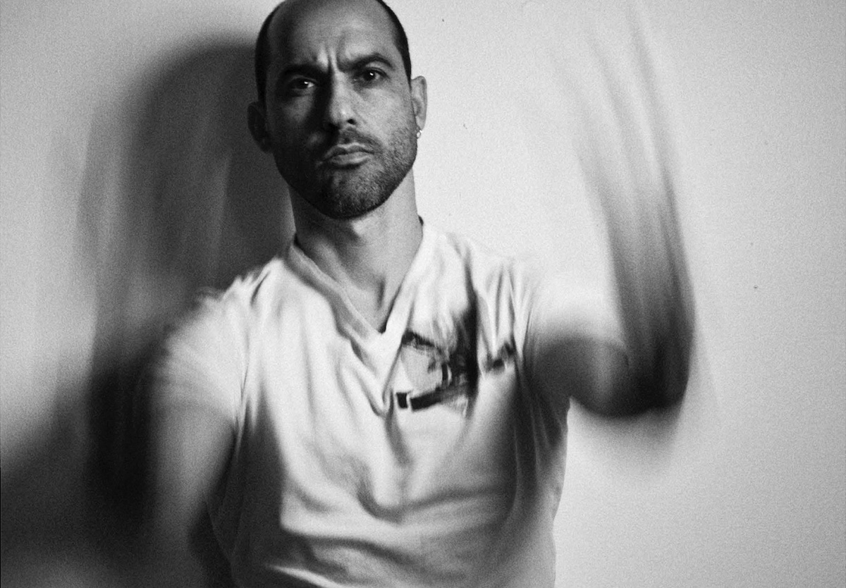 A striking black-and-white portrait of Carmine Groe, highlighting his thoughtful expression and artistic persona.