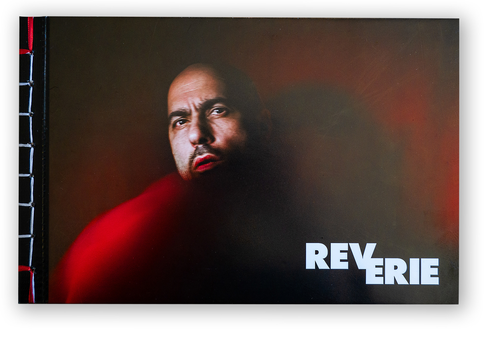 Cover of Carmine Groe's new book 'Reverie,' featuring a dramatic red background and an artistic self-portrait of the author.