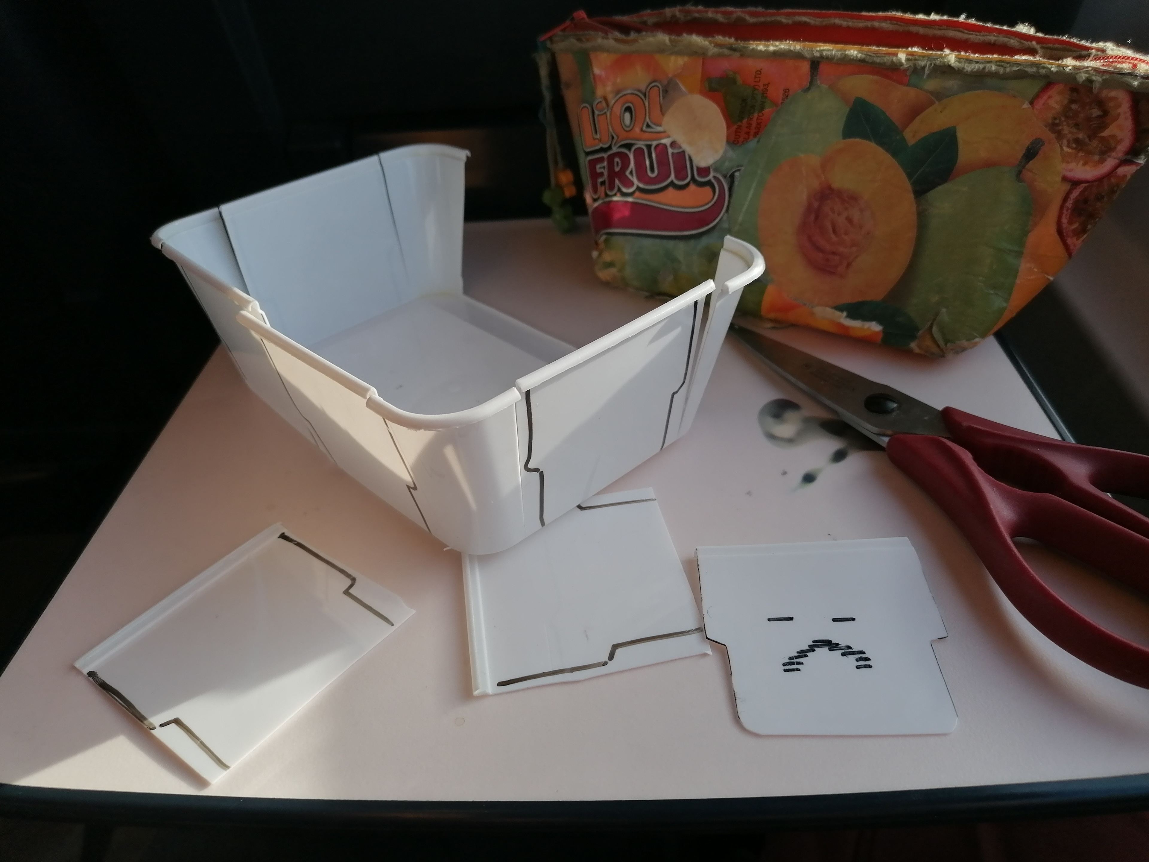 cutting his replacement faces from a takeaway food container. the faces were drawn by our teammate Manasse