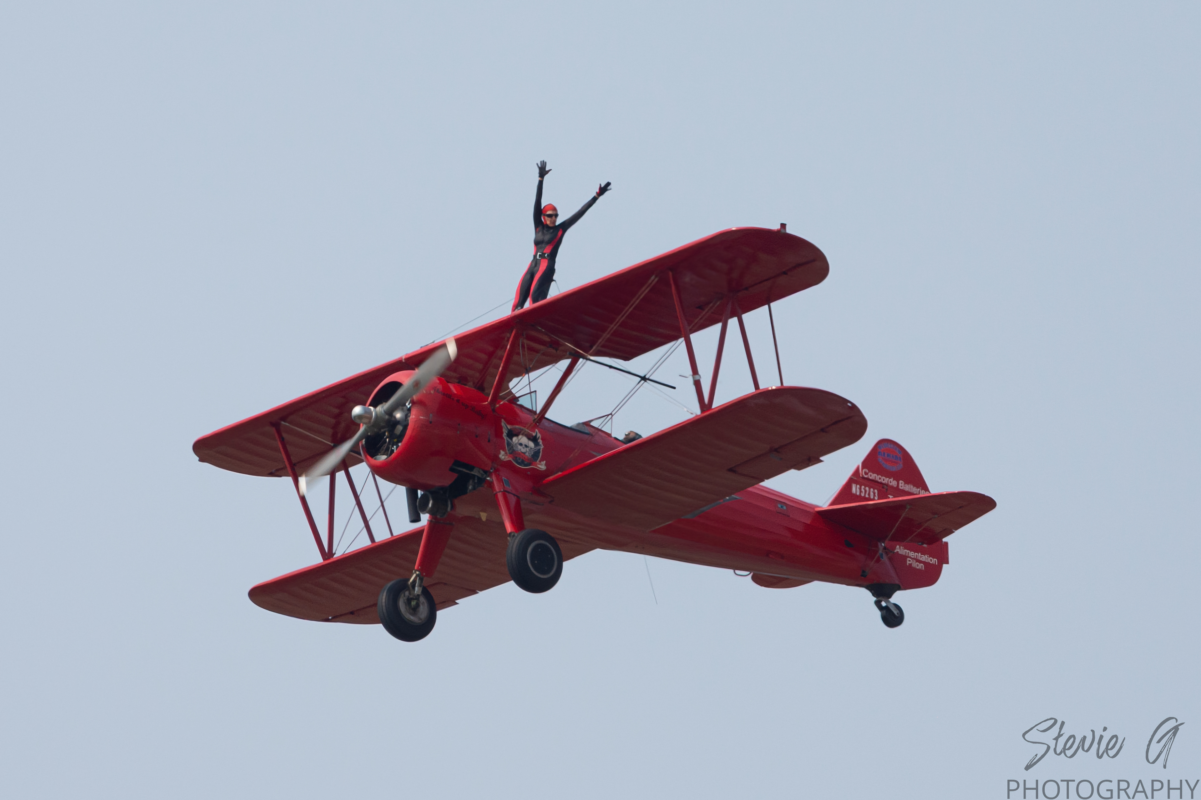 Stunt atop a red 1940 Boeing-Stearman biplane during an airshow display