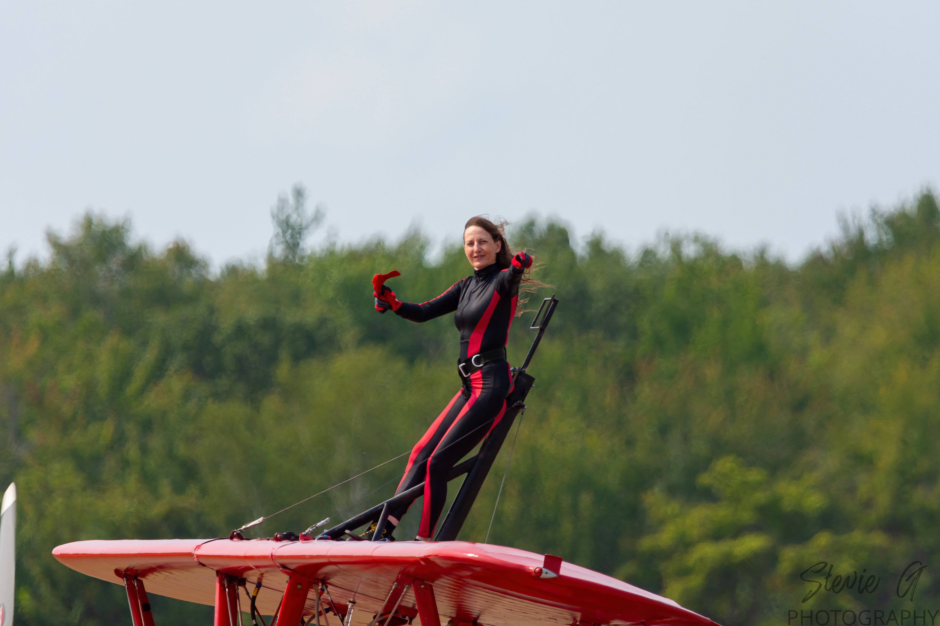 Stunt atop a red 1940 Boeing-Stearman biplane during an airshow display. 