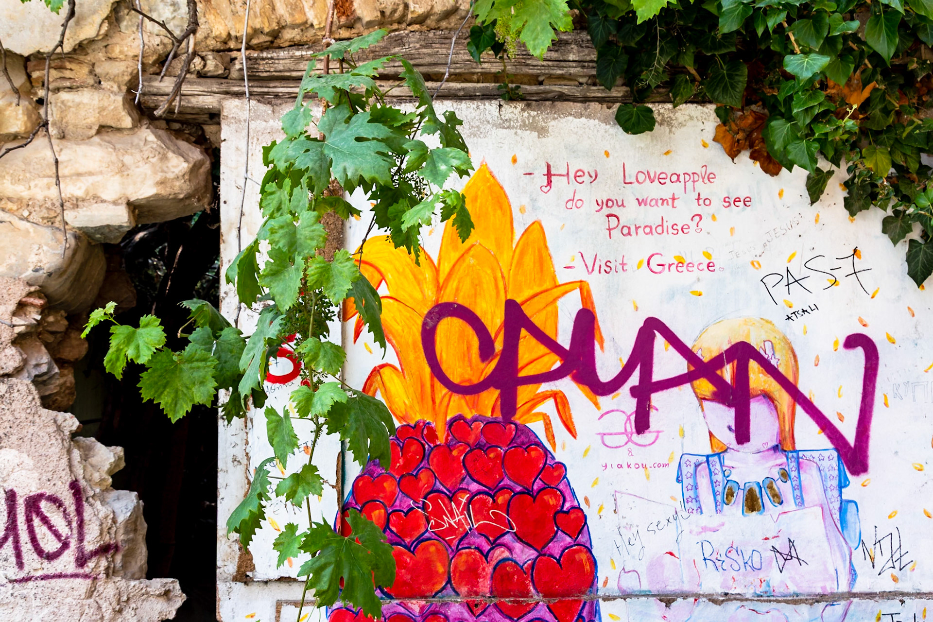 Athens, Greece - May 23rd 2018: Graffiti art on a wall with a message "Hey Loveapple do you want to see Paradise? Visit Greece" and other tags.